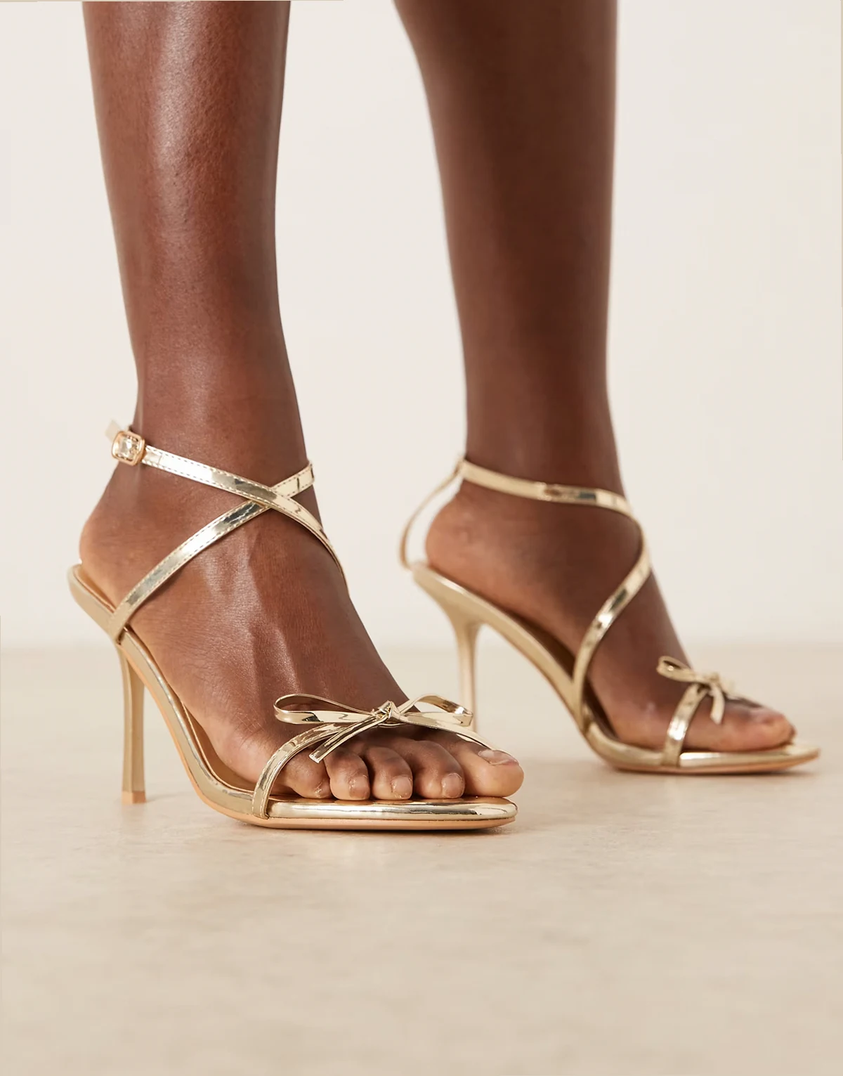 – Filigrane Sandaletten in Goldoptik mit Schleifendetail, weite Passform
