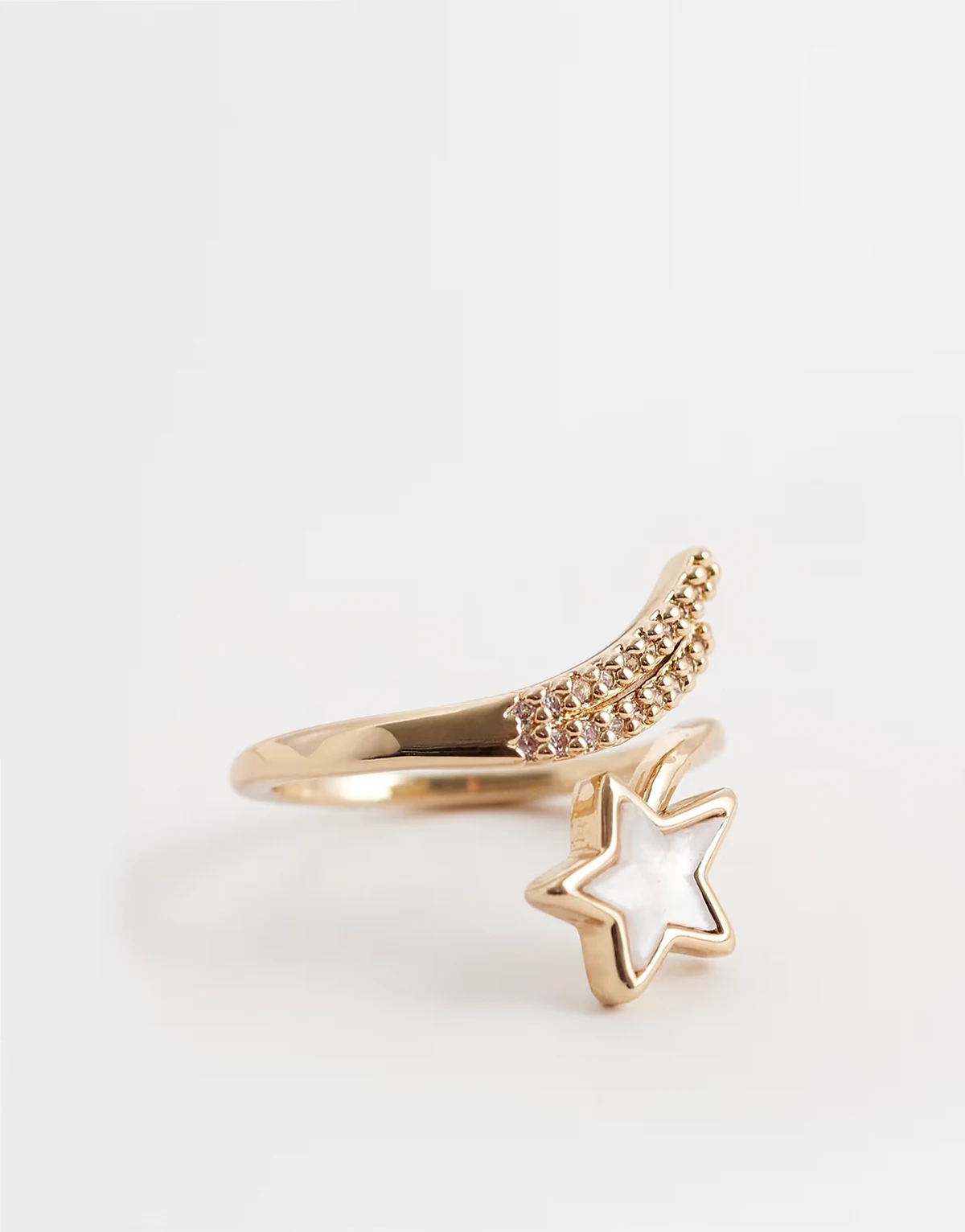 ring with wrap around detail in gold tone with white enamel star