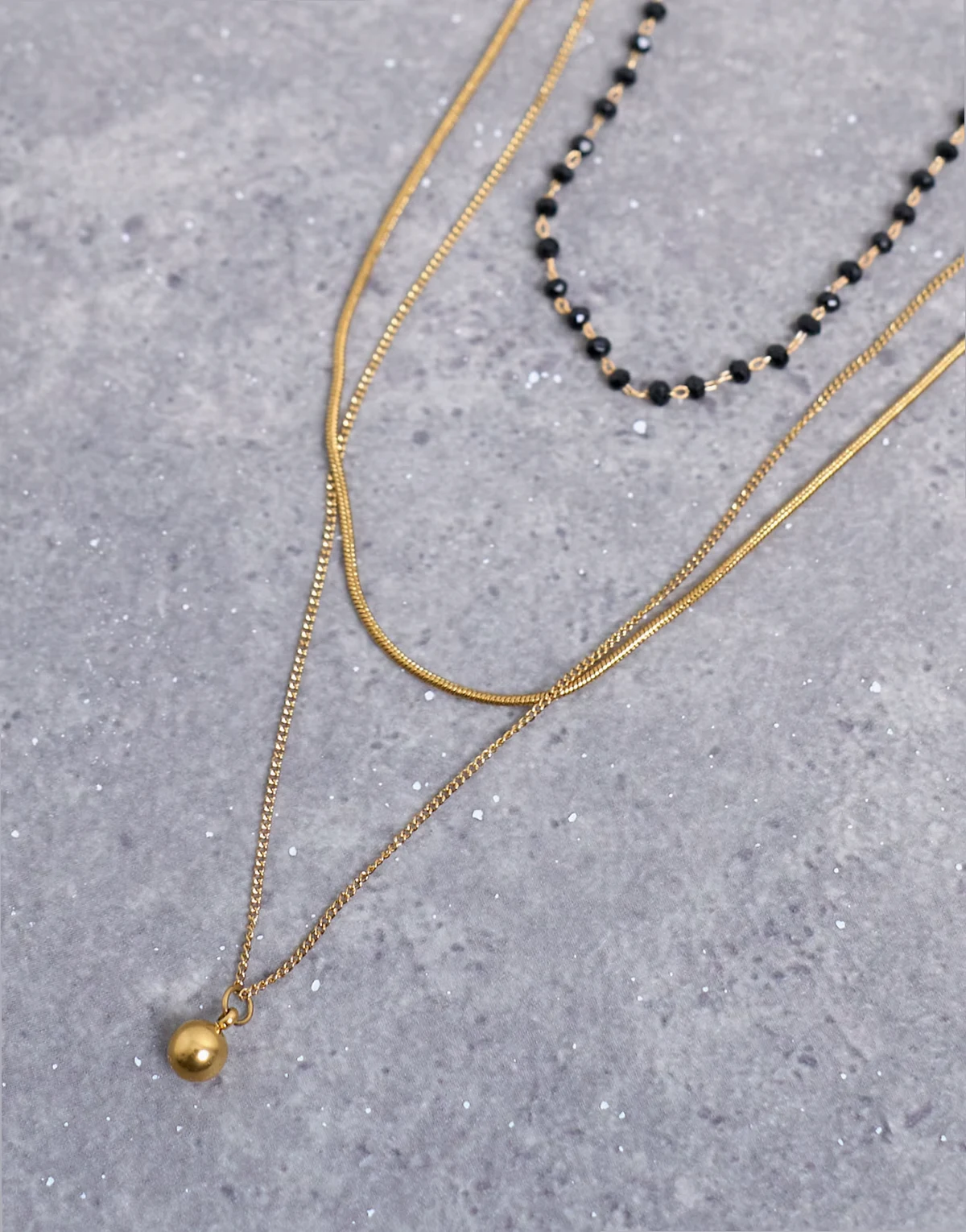 – Maddox – Wielorzędowy naszyjnik z różnych łańcuszków ze stali nierdzewnej w kolorze złota z czarnymi koralikami