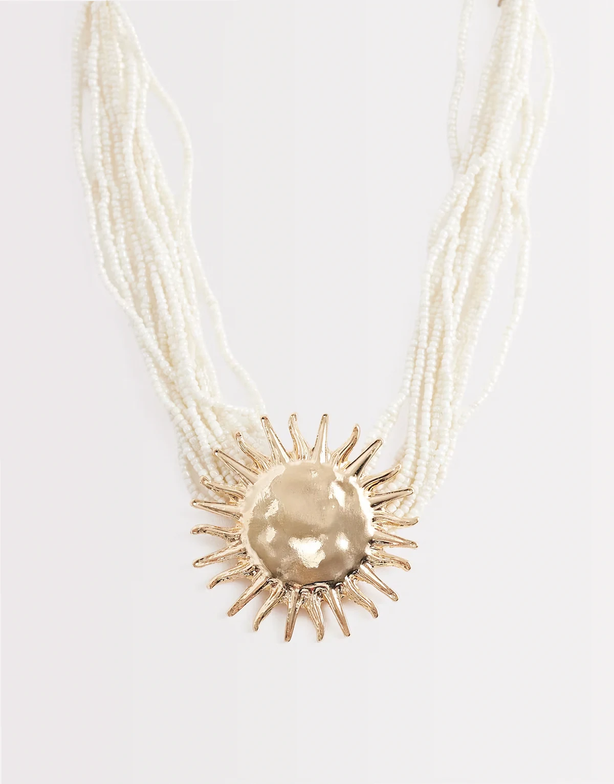 – Naszyjnik z perełek z zawieszką w kształcie słońca