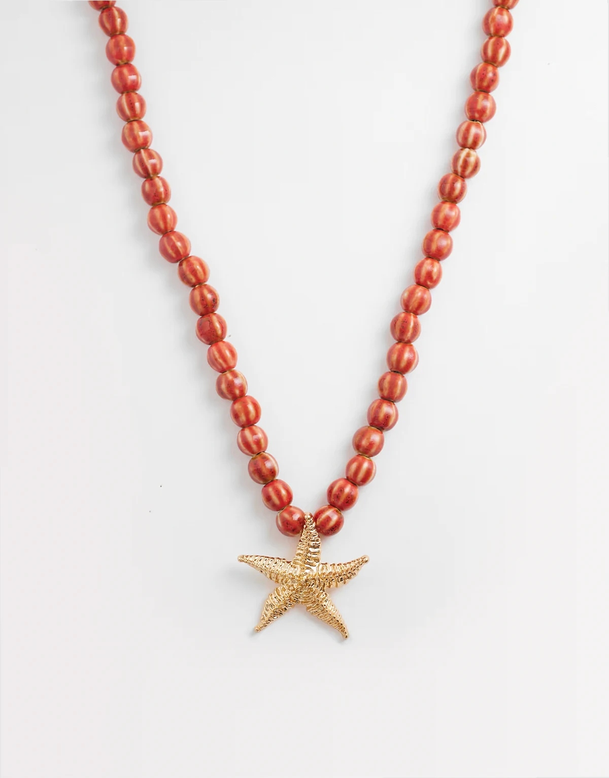 – Czerwony, gruby naszyjnik z koralikami i rozgwiazdą