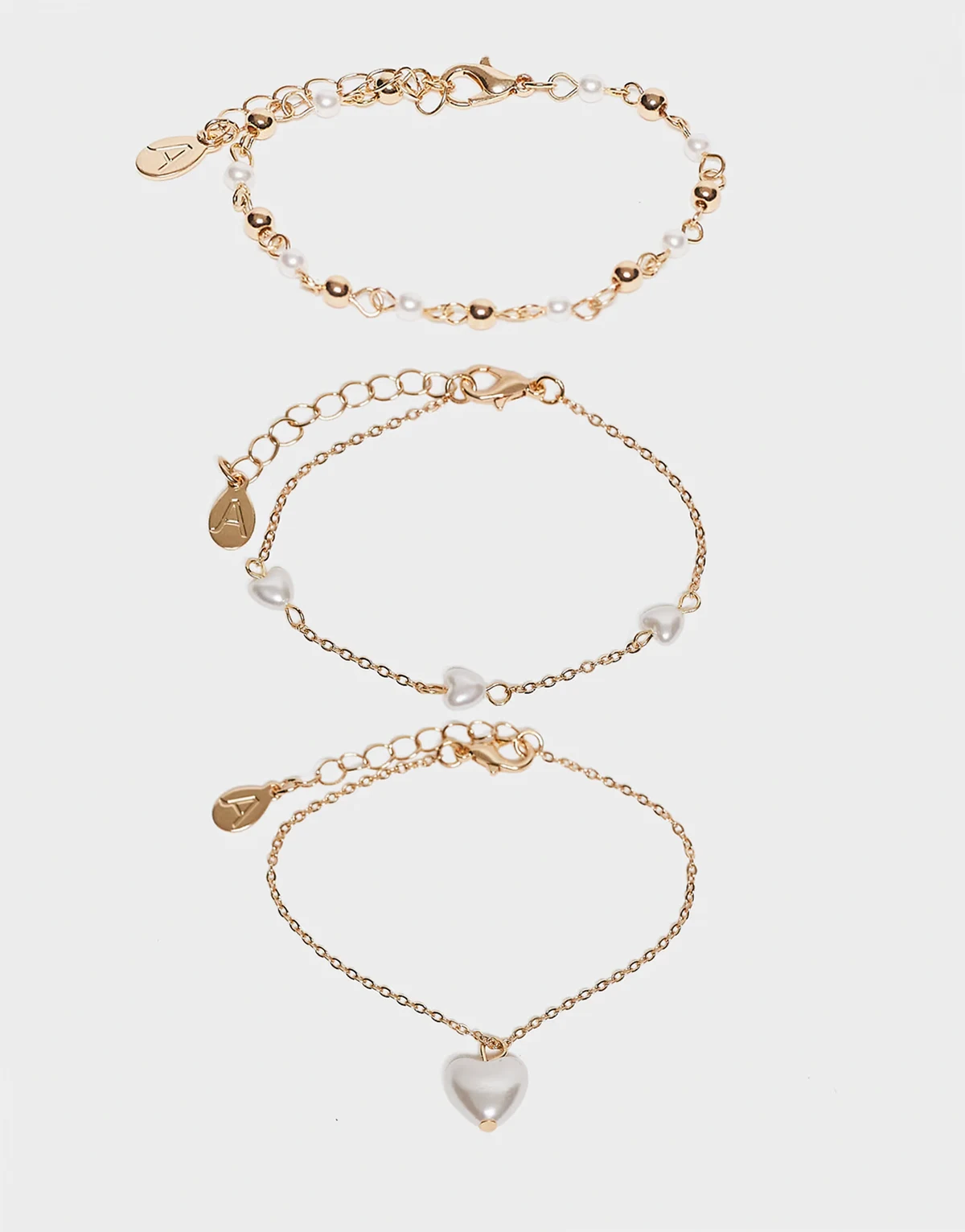 – Zestaw 3 delikatnych bransoletek ze sztucznymi perełkami w kolorze złota z zawieszkami w kształcie serca