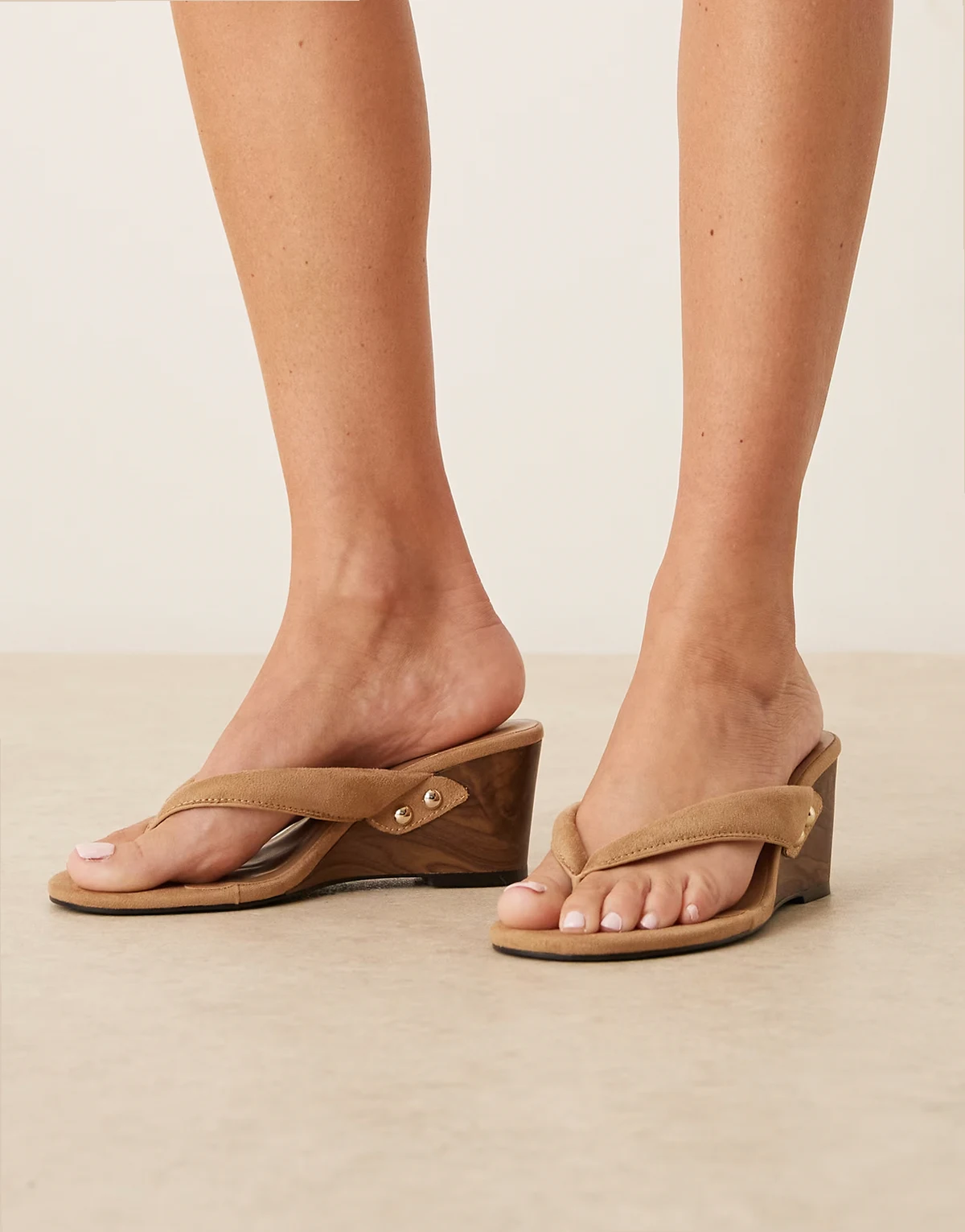 – Zehenstegsandalen aus Wildleder in Neutral mit Keilabsatz