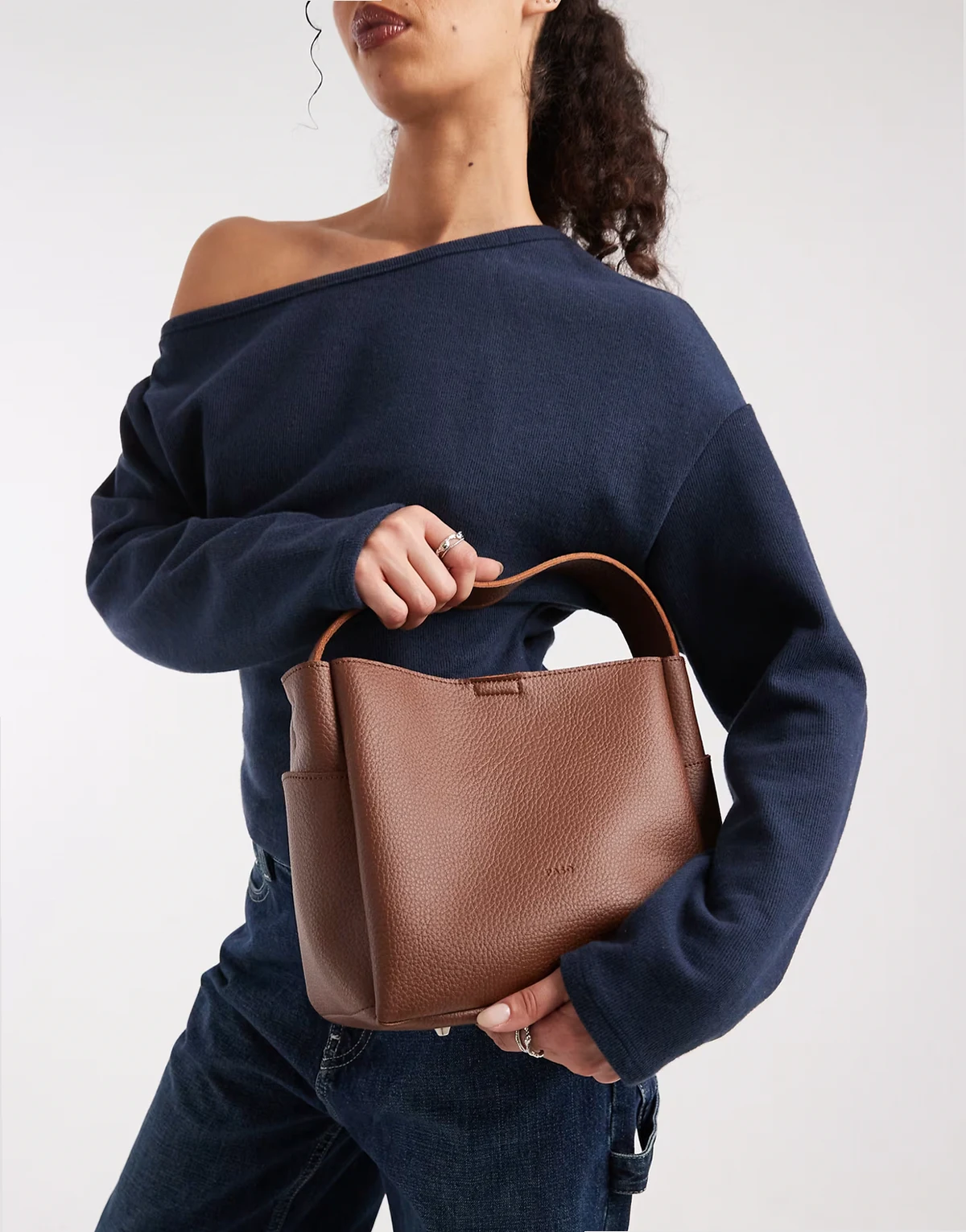 – Brązowa torebka typu bucket z paskiem crossbody