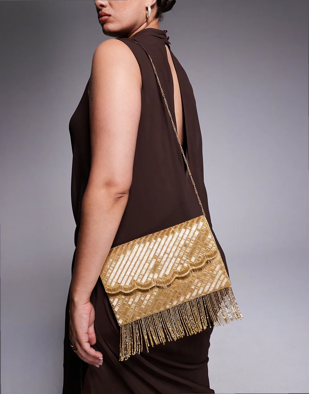 – Mit Quasten verzierte Kuvert-Clutch in Goldoptik