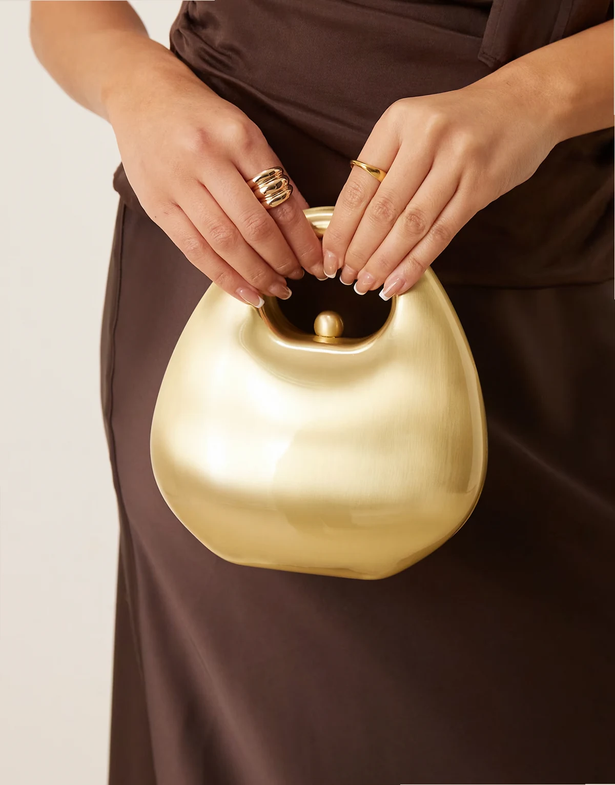 – Sztywna kopertówka z rączką w kolorze szczotkowanego złota