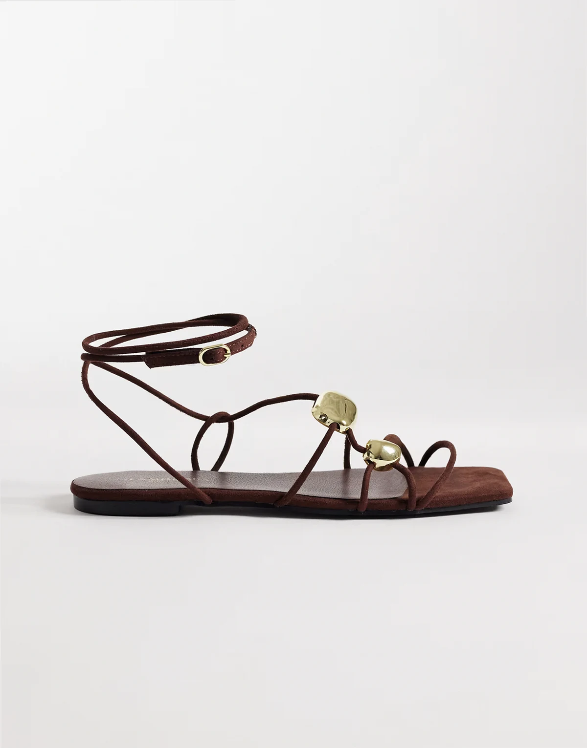 – Flache Sandalen aus braunem Wildlederimitat mit goldfarbenem Detail
