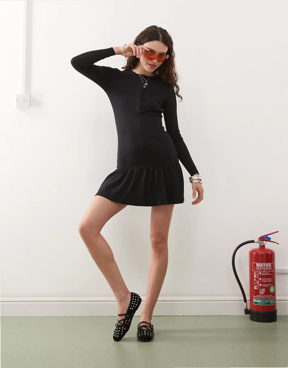 – Minikleid in geripptem Schwarz mit Henley-Ausschnitt und tiefer Taille