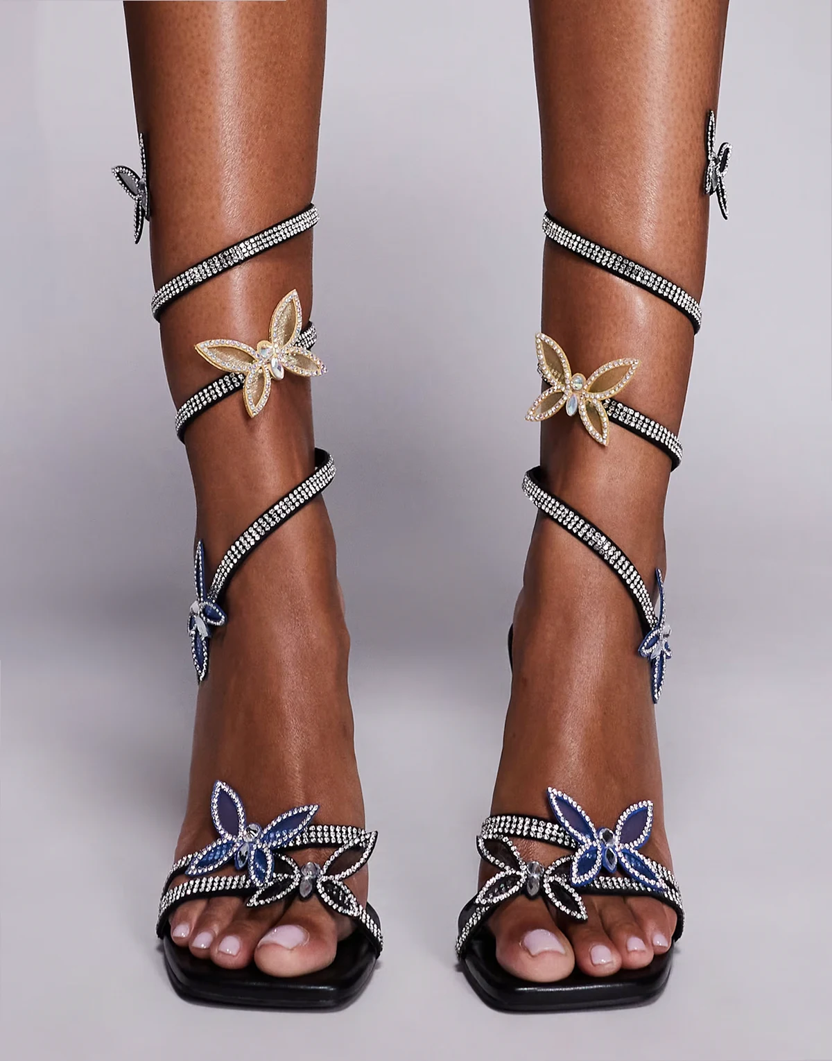– Zarya – Sandaletten in Schwarz mit spiralförmigem Riemen, hohem Absatz und Schmetterling-Details