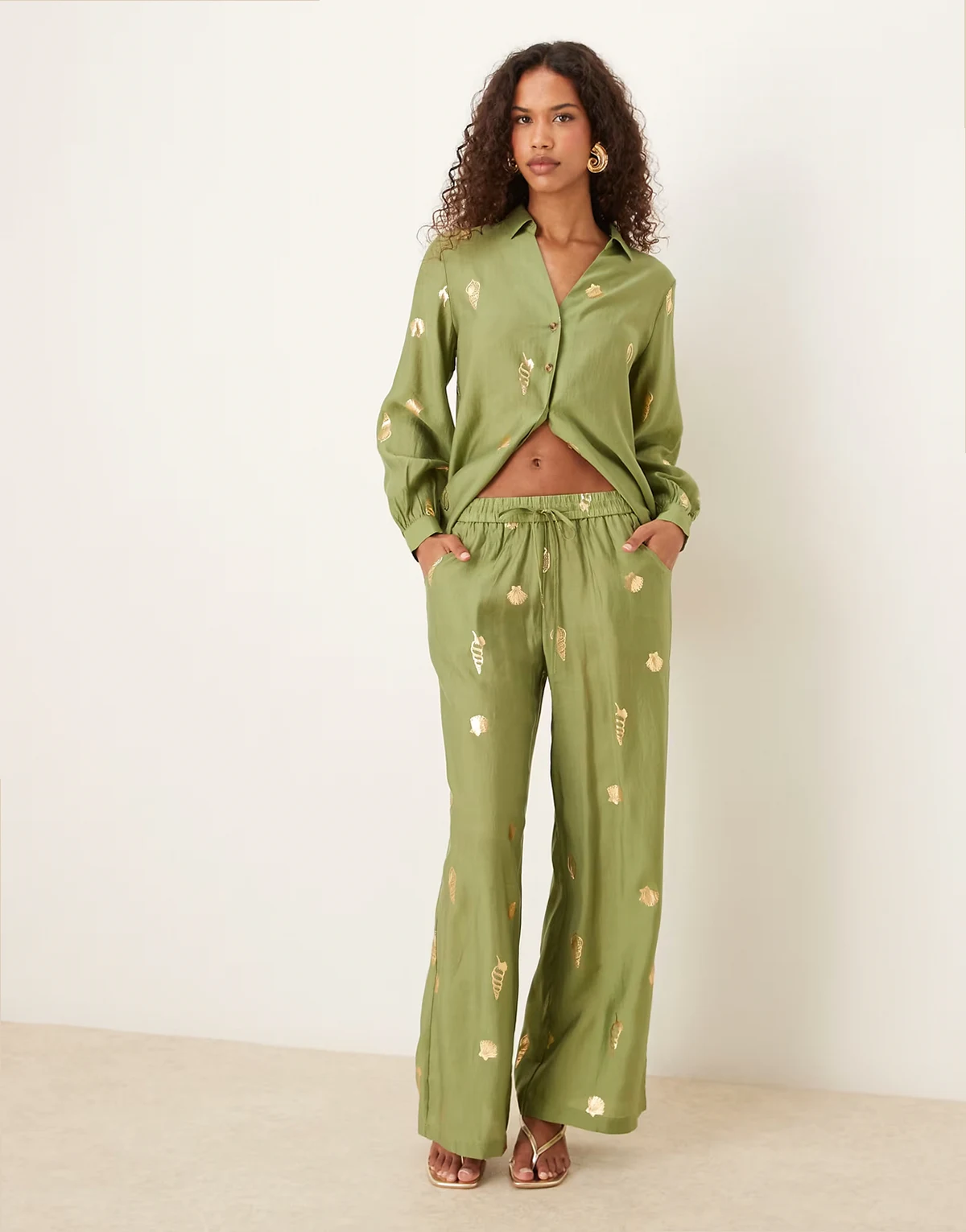 – Spodnie z szerokimi nogawkami w kolorze khaki z foliowanym złotym nadrukiem w muszle, część zestawu