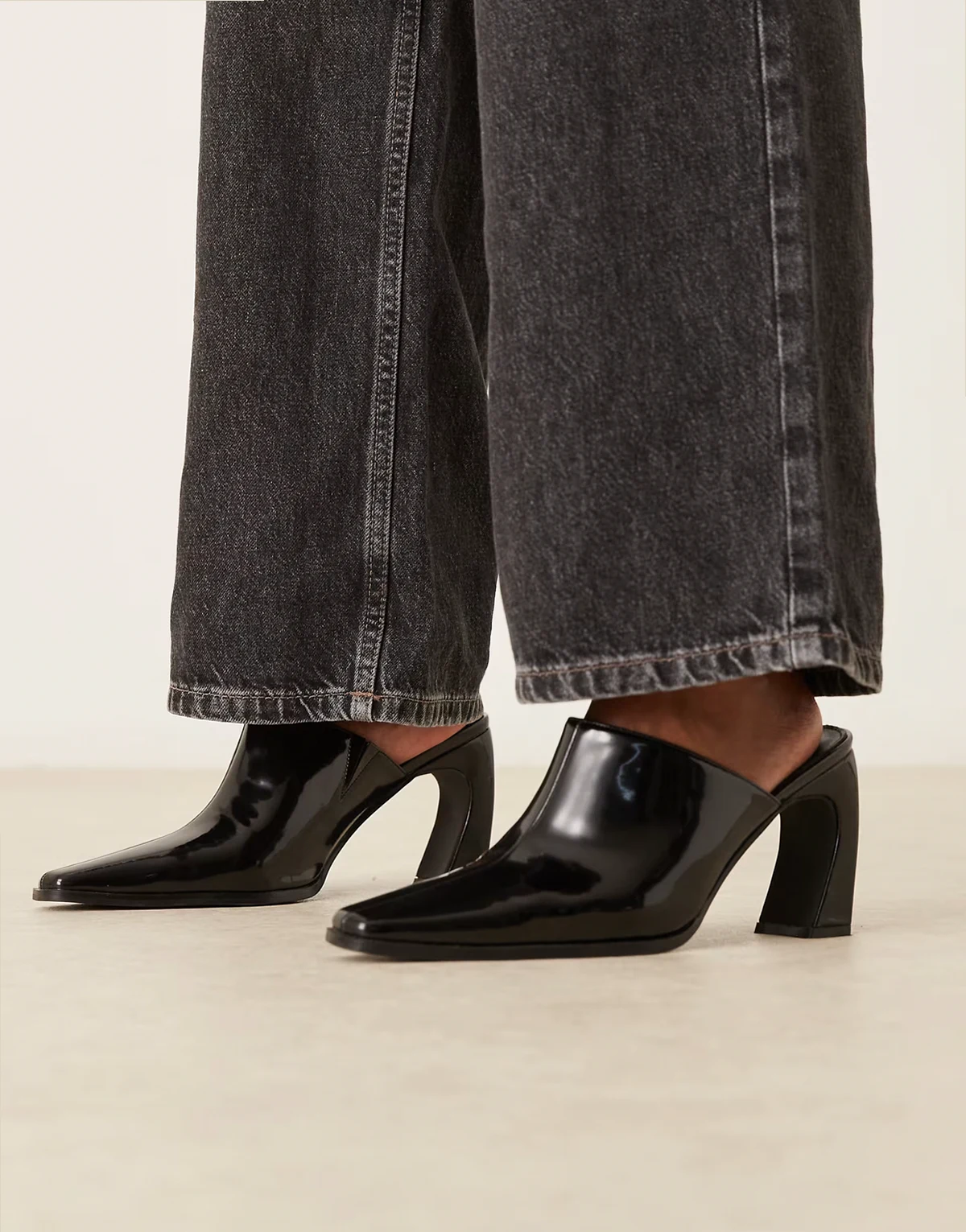 – Hania – Mules in Schwarz mit gebogenem Absatz und spitzer Zehenpartie