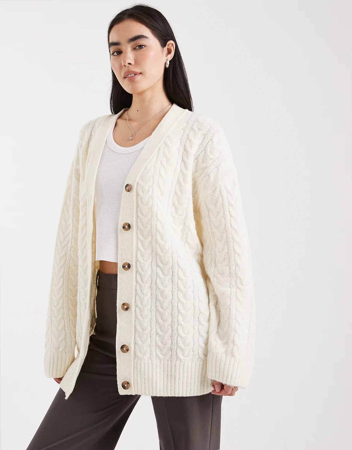 – Lang geschnittene Oversize-Strickjacke in Creme mit Zopfmuster
