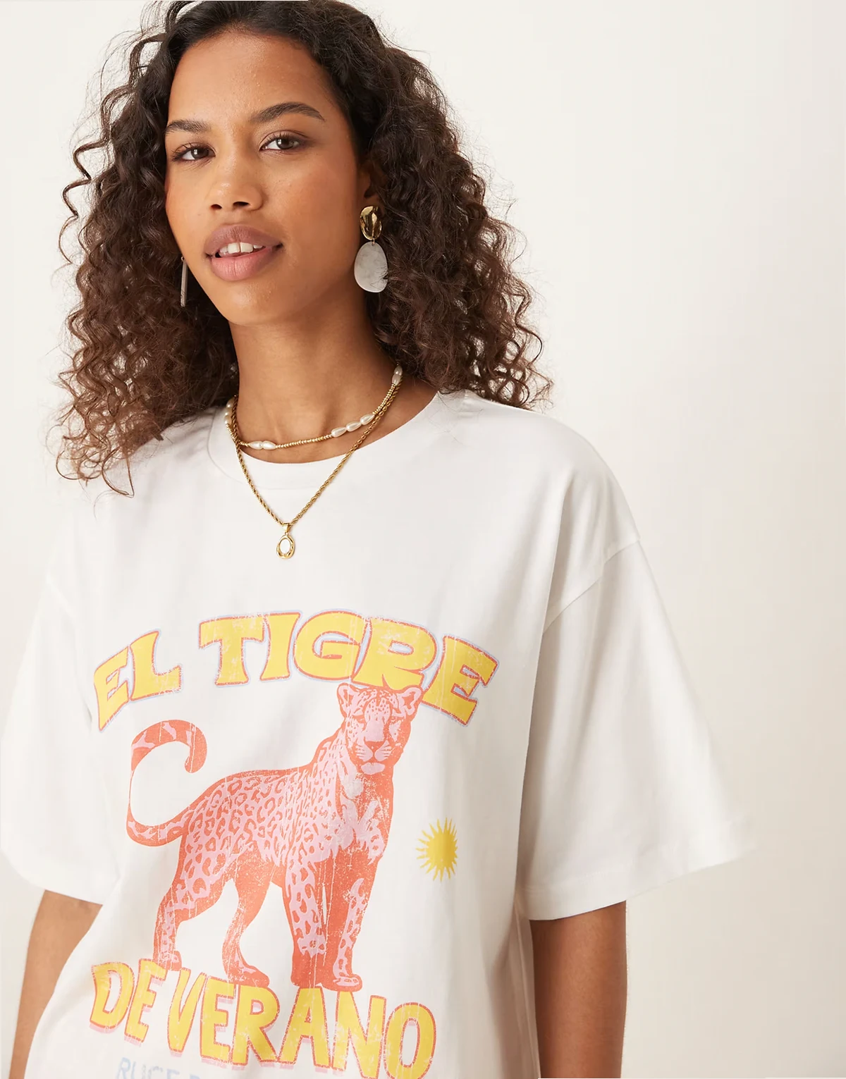 – Kremowy T-shirt oversize z grafiką z różowym tygrysem