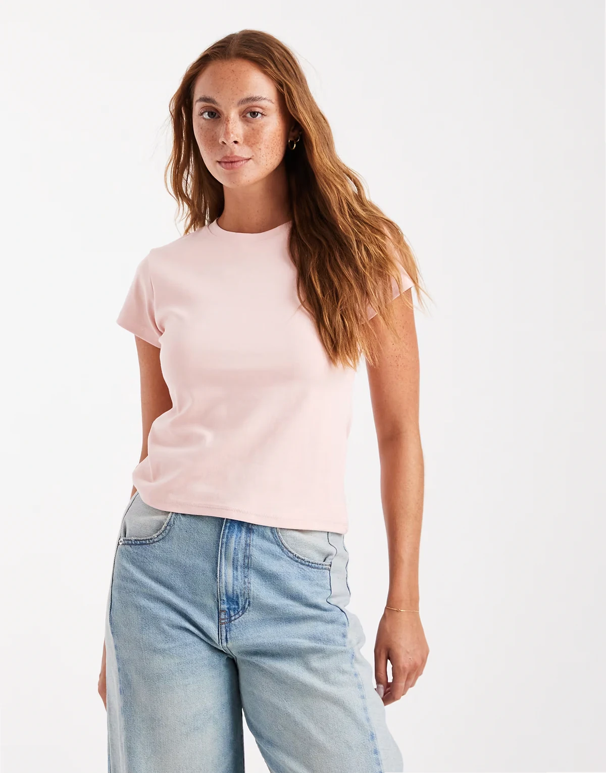 – Jasnoróżowy krótki i dopasowany T-shirt w stylu lat 90.