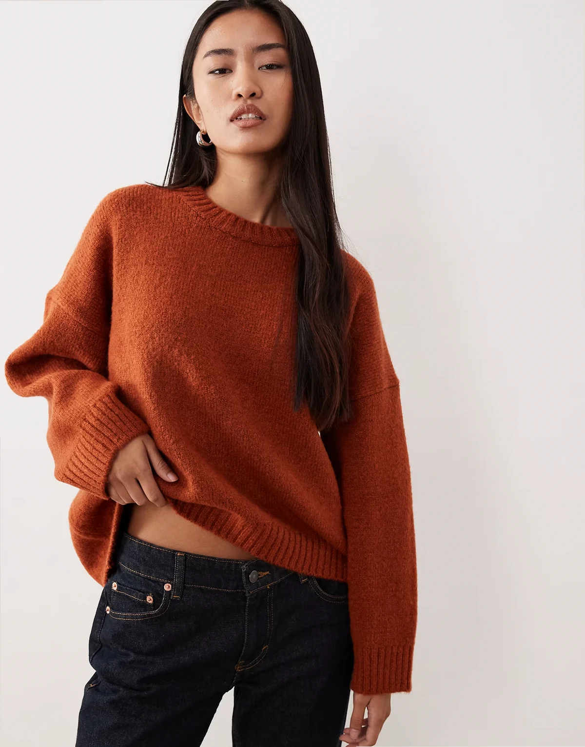 – Miedziany sweter oversize z okrągłym dekoltem i zaokrąglonym dołem
