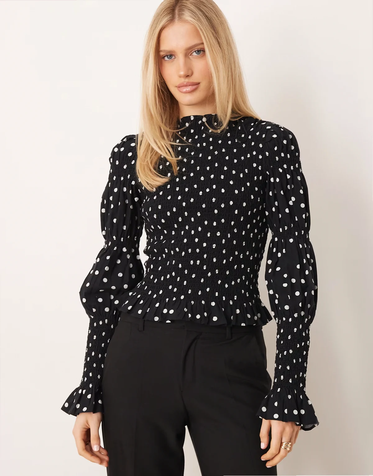 – Langärmliges, hochgeschlossenes Hängeroberteil in Schwarz mit weißen Polka Dots