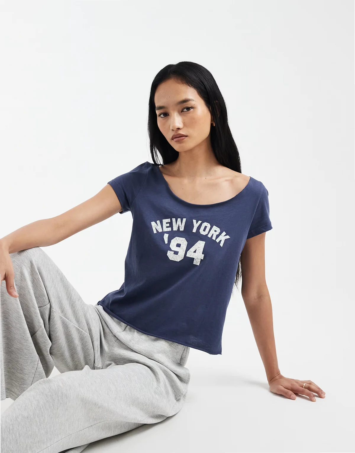 – Stalowoniebieski T-shirt z odkrytymi ramionami i grafiką z napisem „New York”