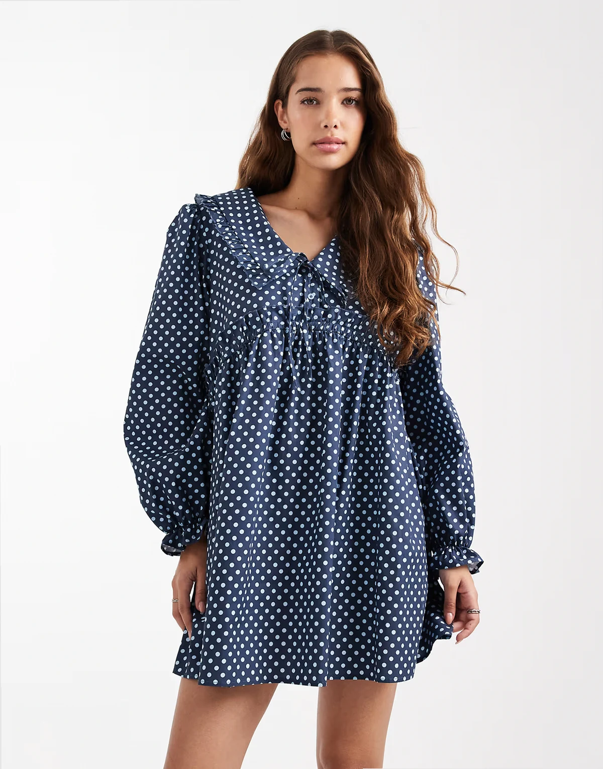 – Luźna sukienka w groszki z obszernymi rękawami i dużym kołnierzem