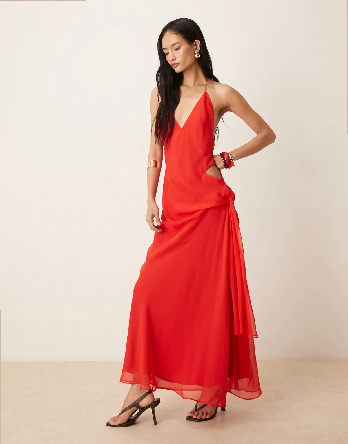 – Cyrel – Czerwona drapowana sukienka maxi z wycięciem, odkrytymi plecami i wiązaniem z boku