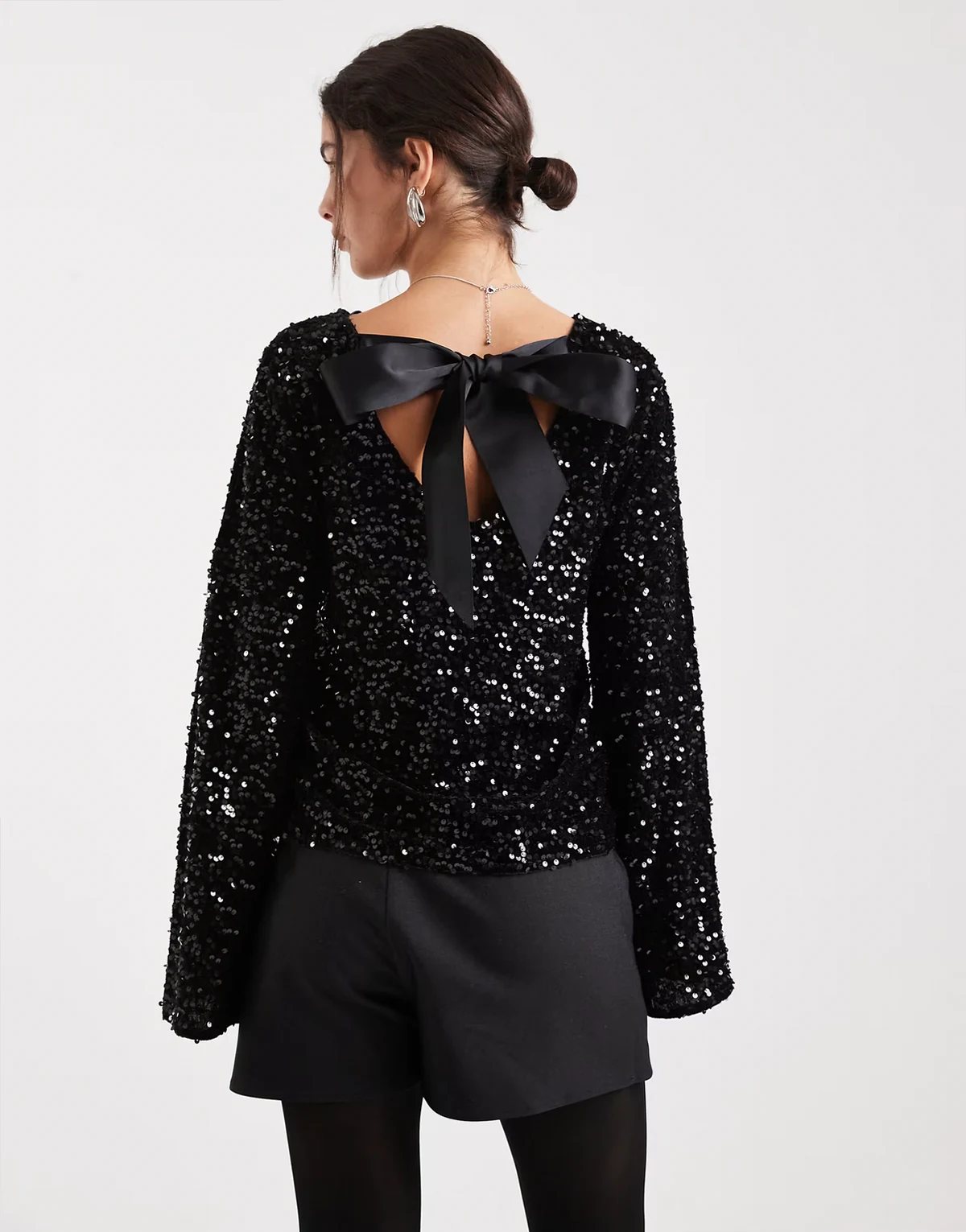 – Czarny cekinowy top z odkrytymi plecami z satynową kokardką