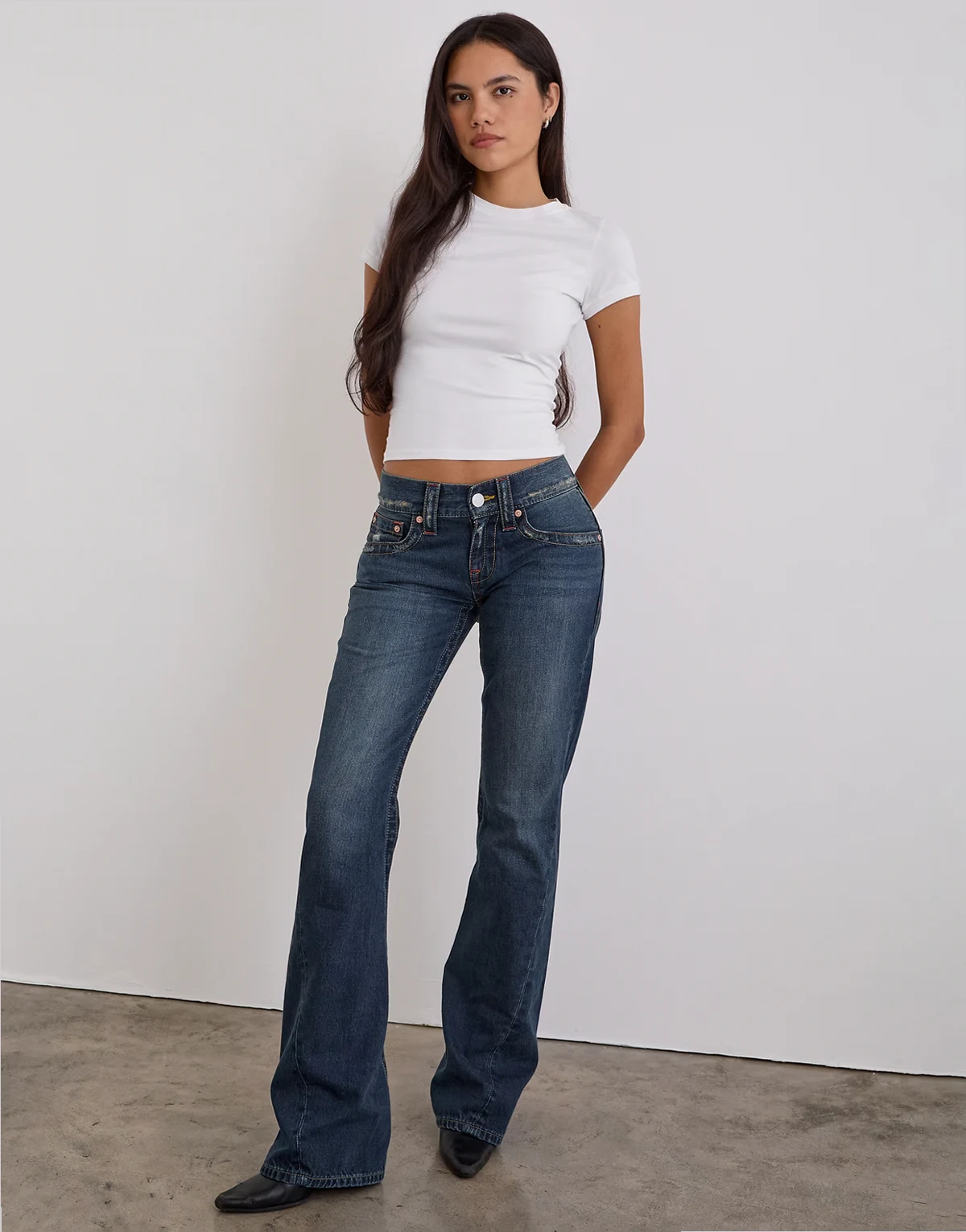 – Jeans in mittelblauer Tönung mit niedrigem Bund und verdrehten Nähten