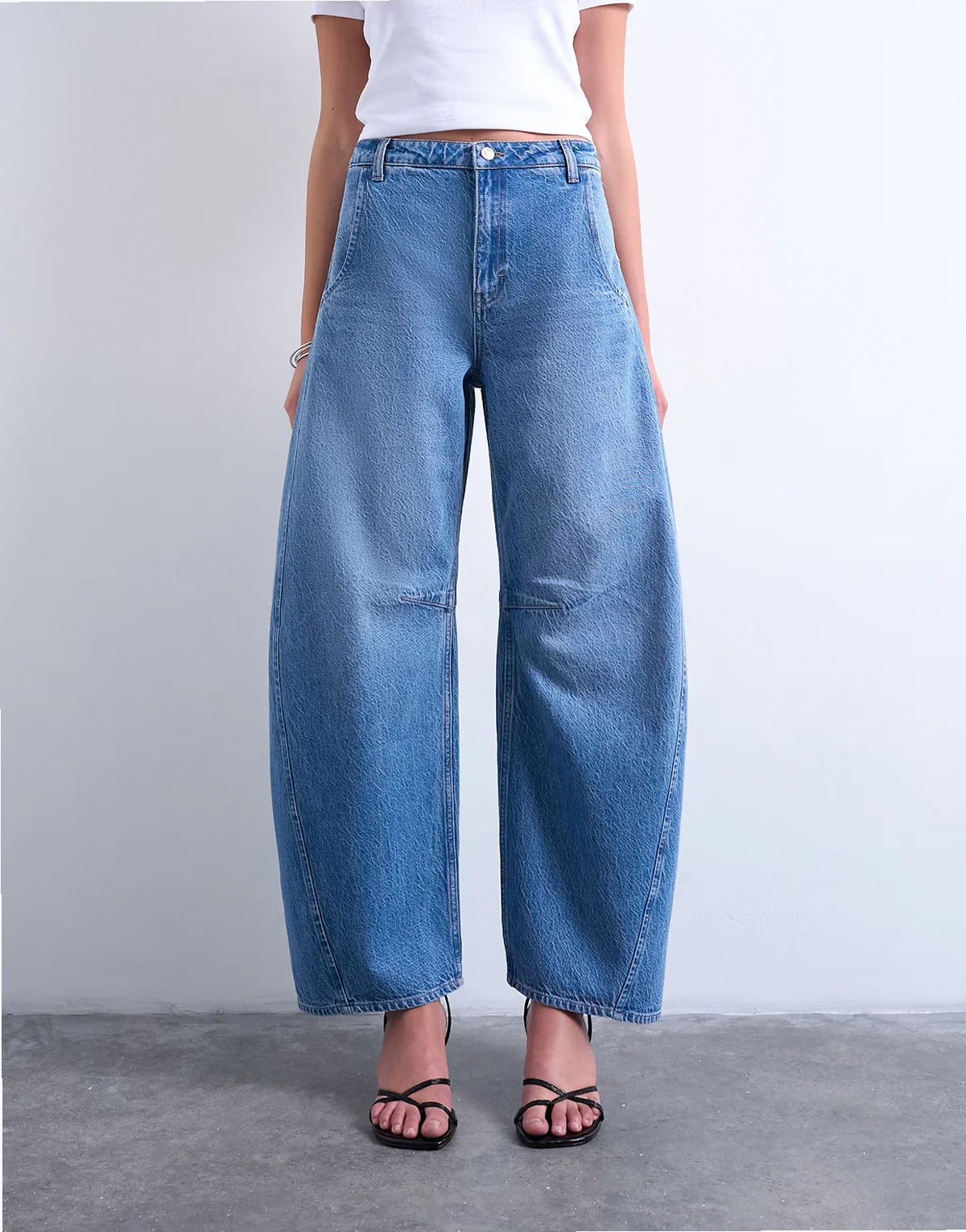 – Niebieskie jeansy z baryłkowymi nogawkami i średnim stanem w stylu vintage