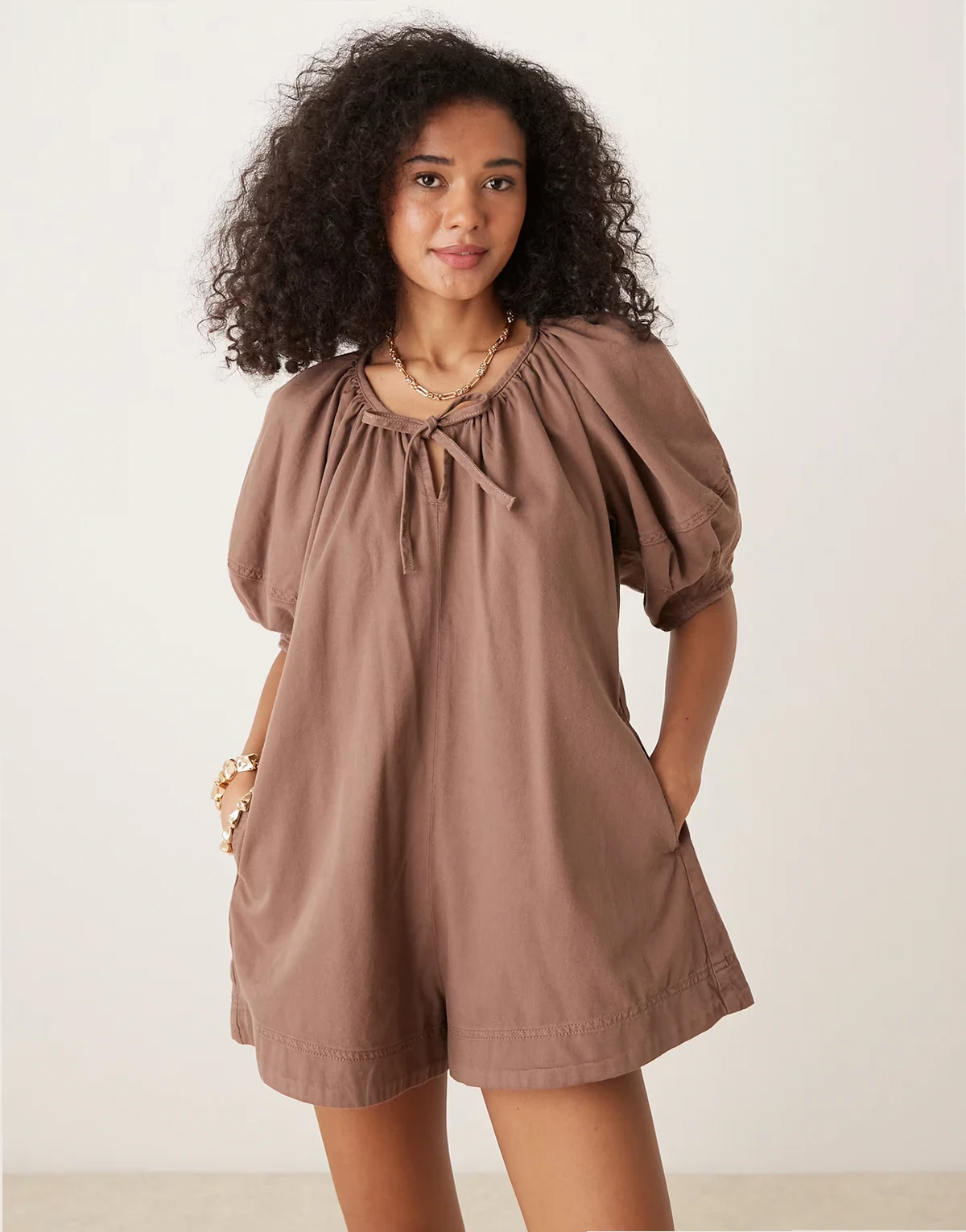 – Krótki kombinezon z miękkiego jeansu z balonowymi rękawami w kolorze mokki
