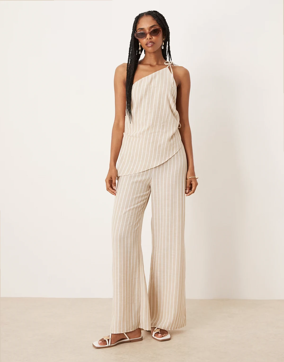– Kamiennobeżowy kombinezon z lnu w paski z asymetrycznym wiązaniem