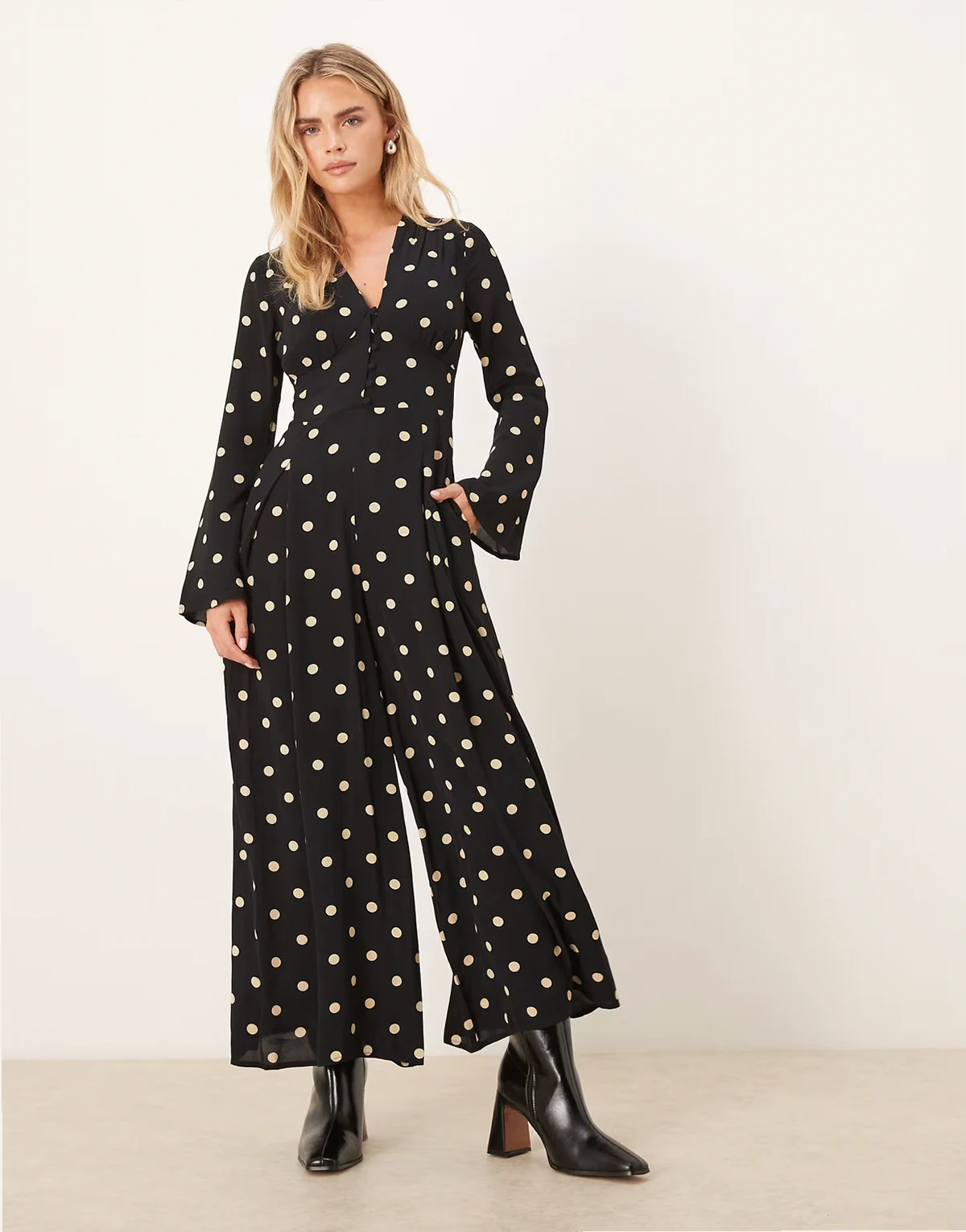 – Valencia – Czarny kombinezon z dekoltem w kształcie litery V i guzikami z przodu w groszki