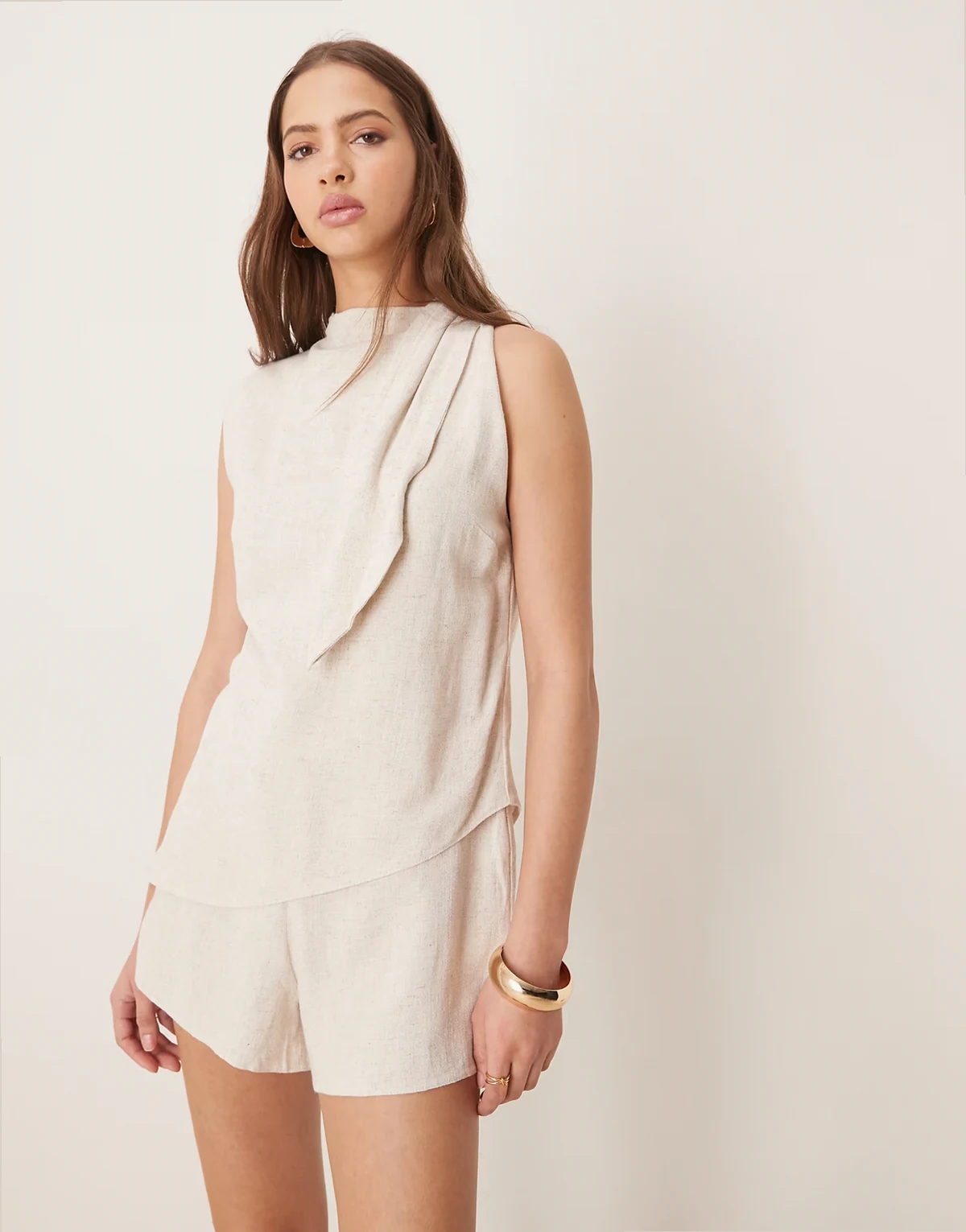 – Jasnobeżowy, krótki kombinezon dwuwarstwowy z apaszką przy dekolcie, z domieszką lnu