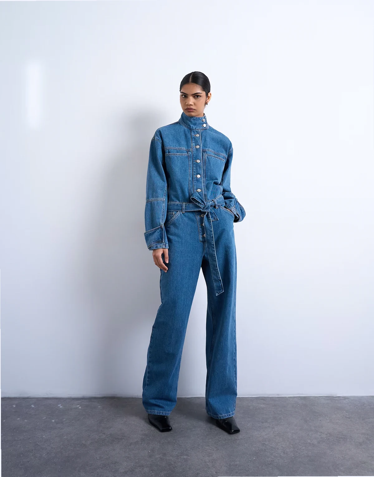 – Niebieski kombinezon jeansowy z paskiem i wysokim kołnierzem