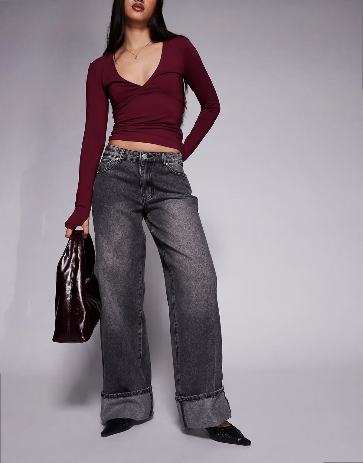 – Ciemnoszare jeansy baggy z podwijanymi nogawkami, regulowanym średnim stanem i kontrastowymi szwami