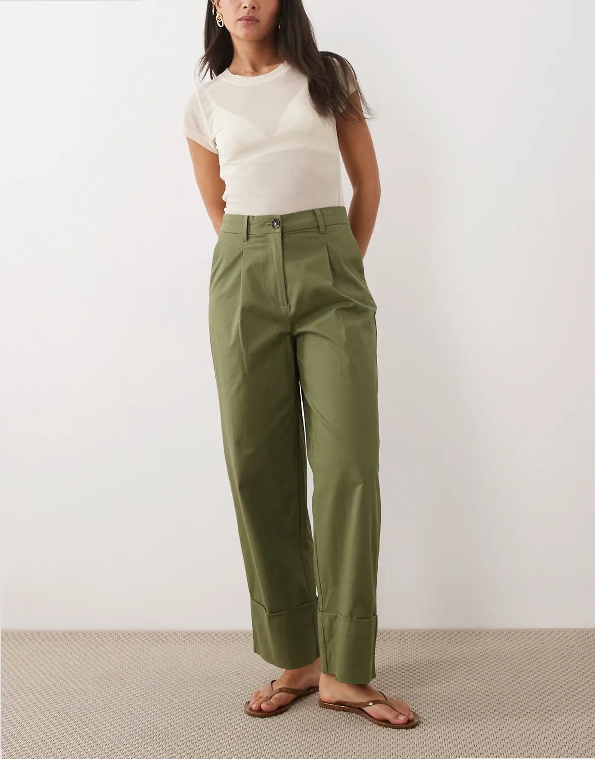 – Oliwkowozielone płócienne spodnie z podwyższonym stanem i wywijanymi nogawkami