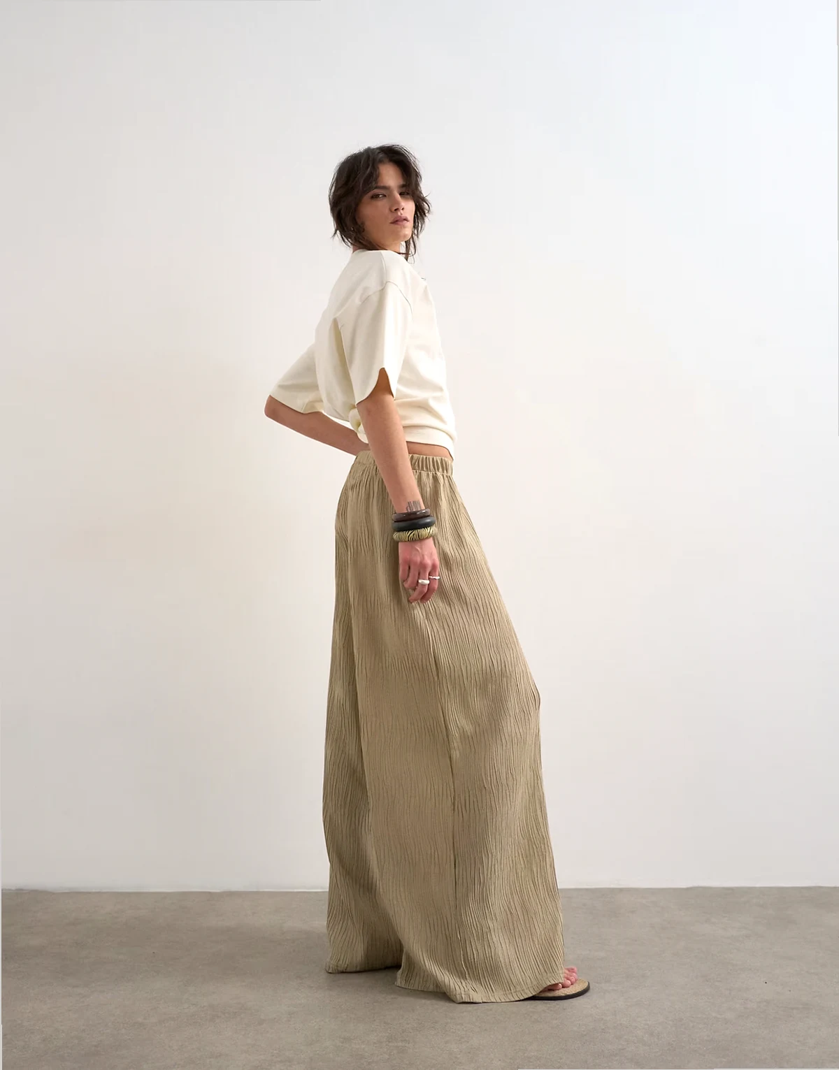 – Beżowe plisowane spodnie z szerokimi nogawkami