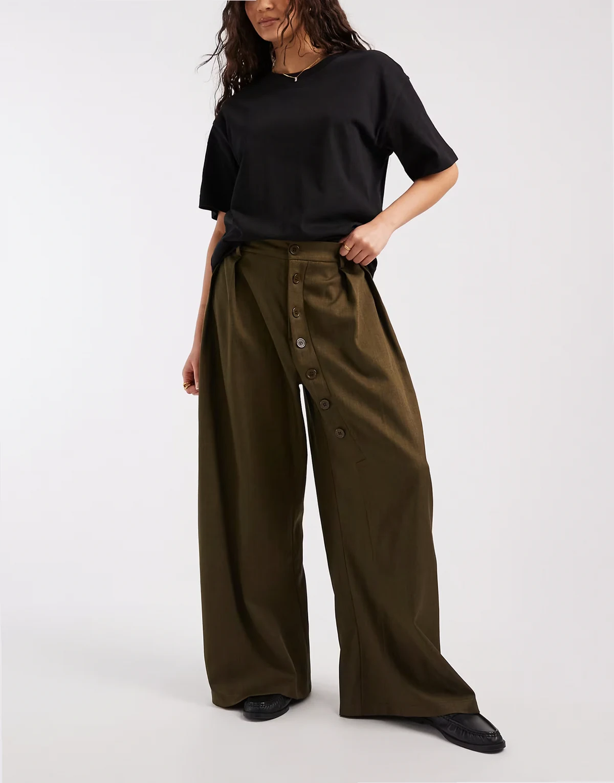 – Spodnie z szerokimi nogawkami, średnim stanem i asymetrycznymi guzikami w oliwkowym odcieniu khaki