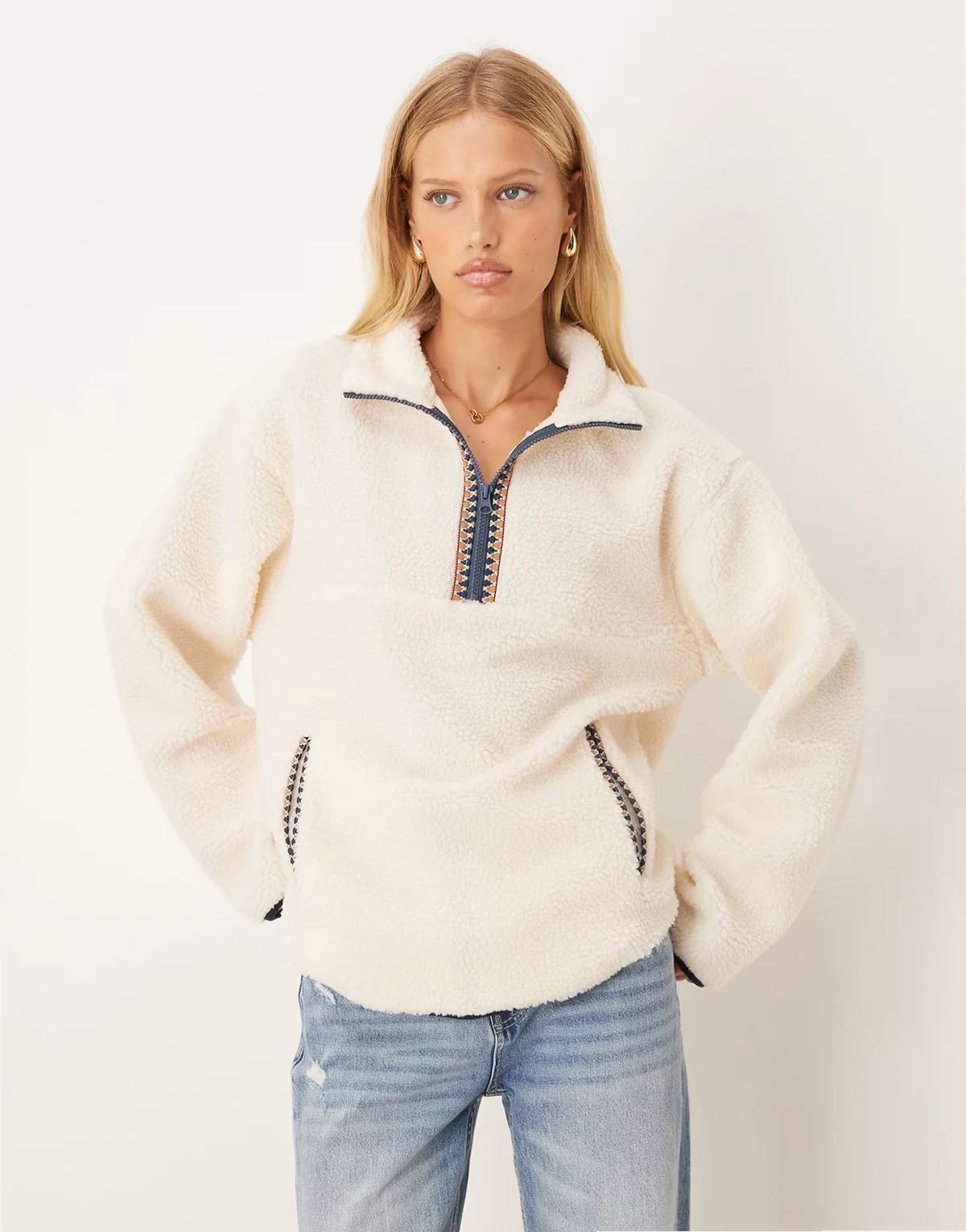 – Sweatshirt aus Teddyfell-Fleece in Creme mit Folklore-Zierstreifen und Reißverschluss