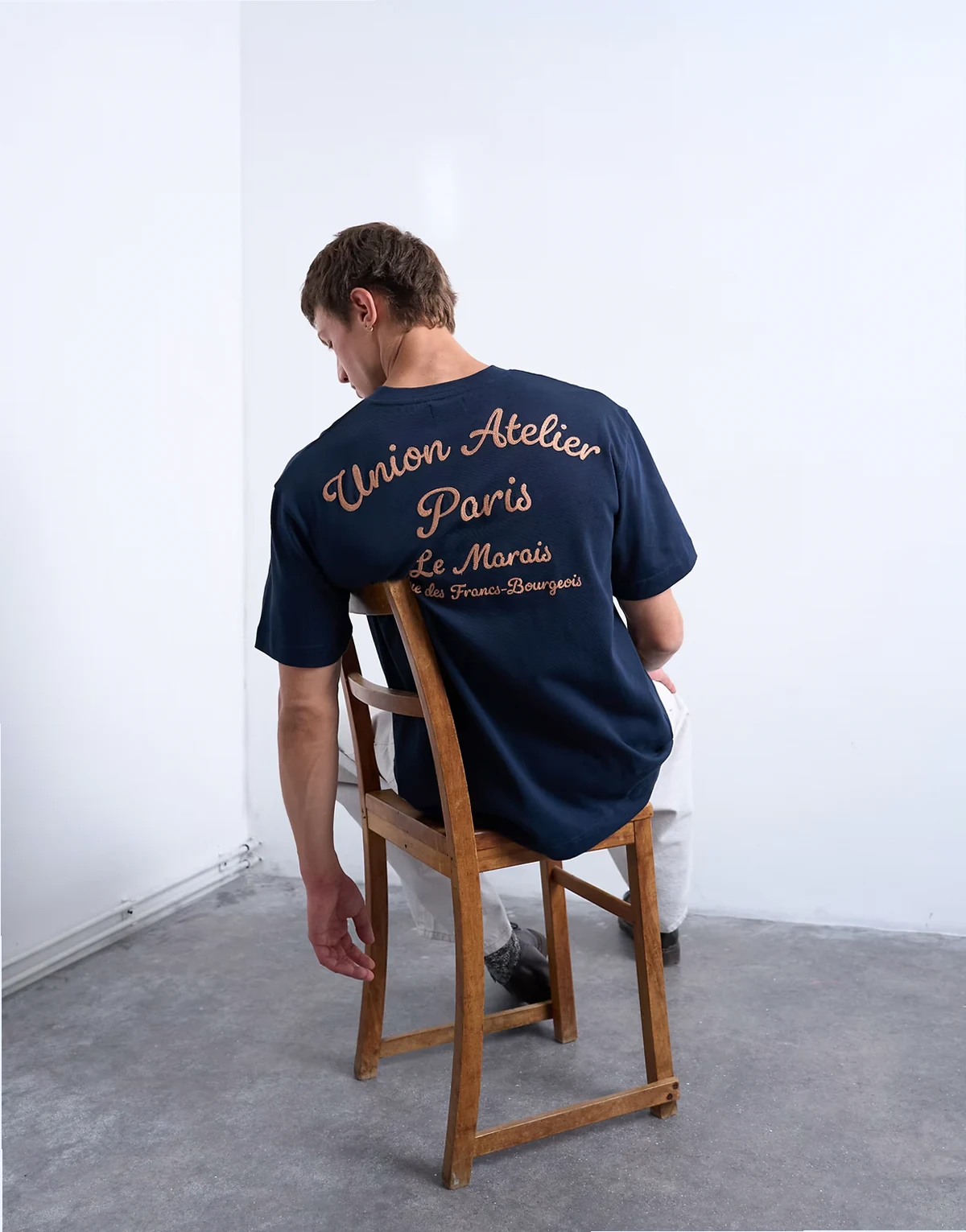 – Granatowy, luźny T-shirt z haftowanym napisem Union Atelier