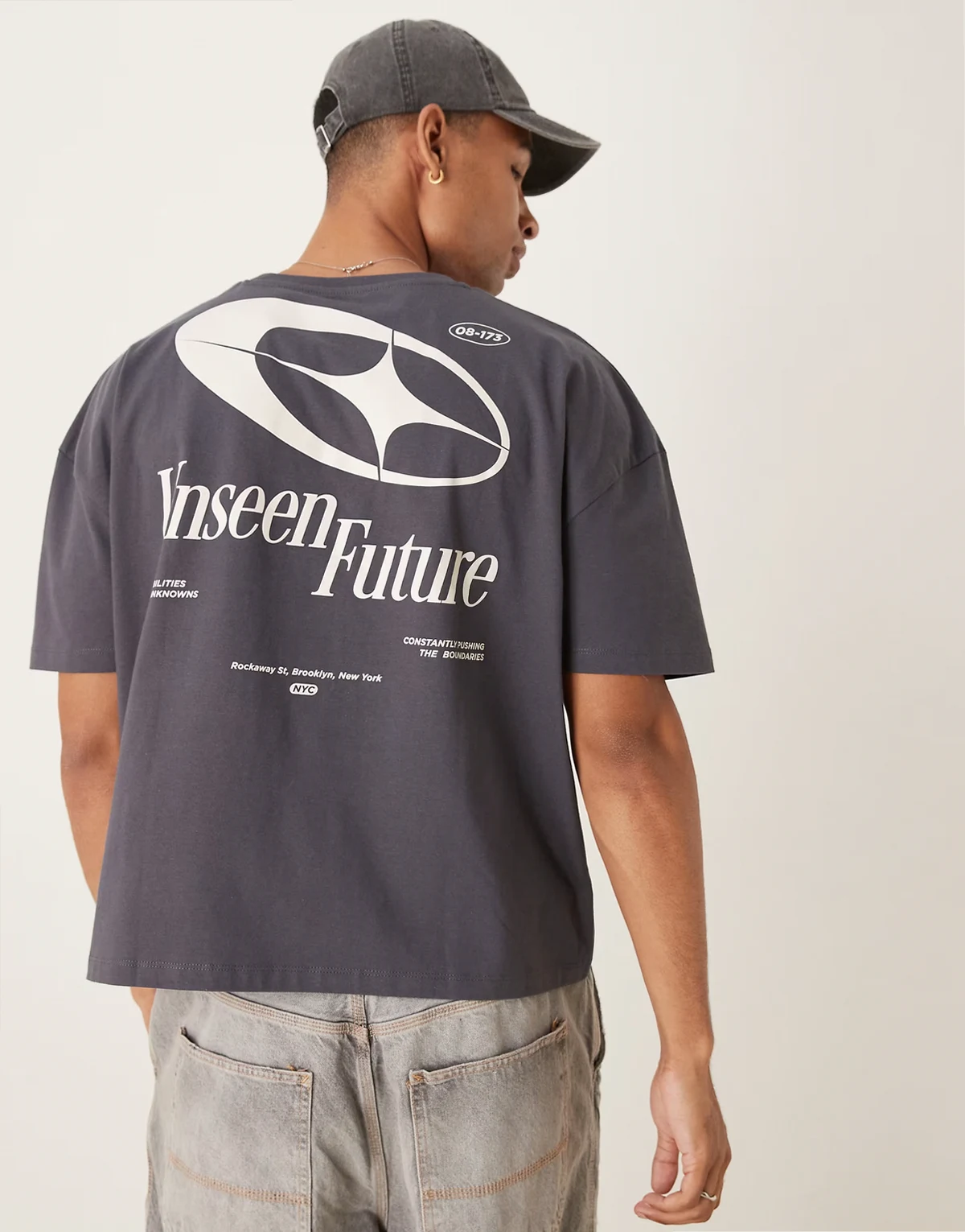 – Grafitowy T-shirt oversize z obniżoną linią ramion i nadrukiem na plecach