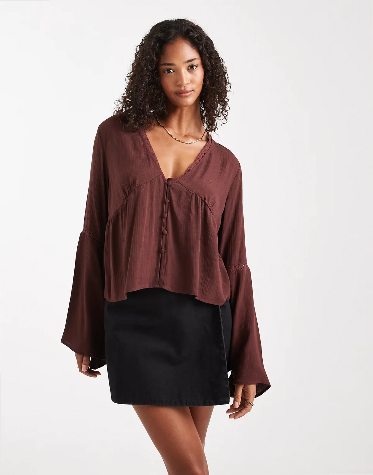 – Brązowa zapinana na guziki bluzka z rozkloszowanymi rękawami i baskinką