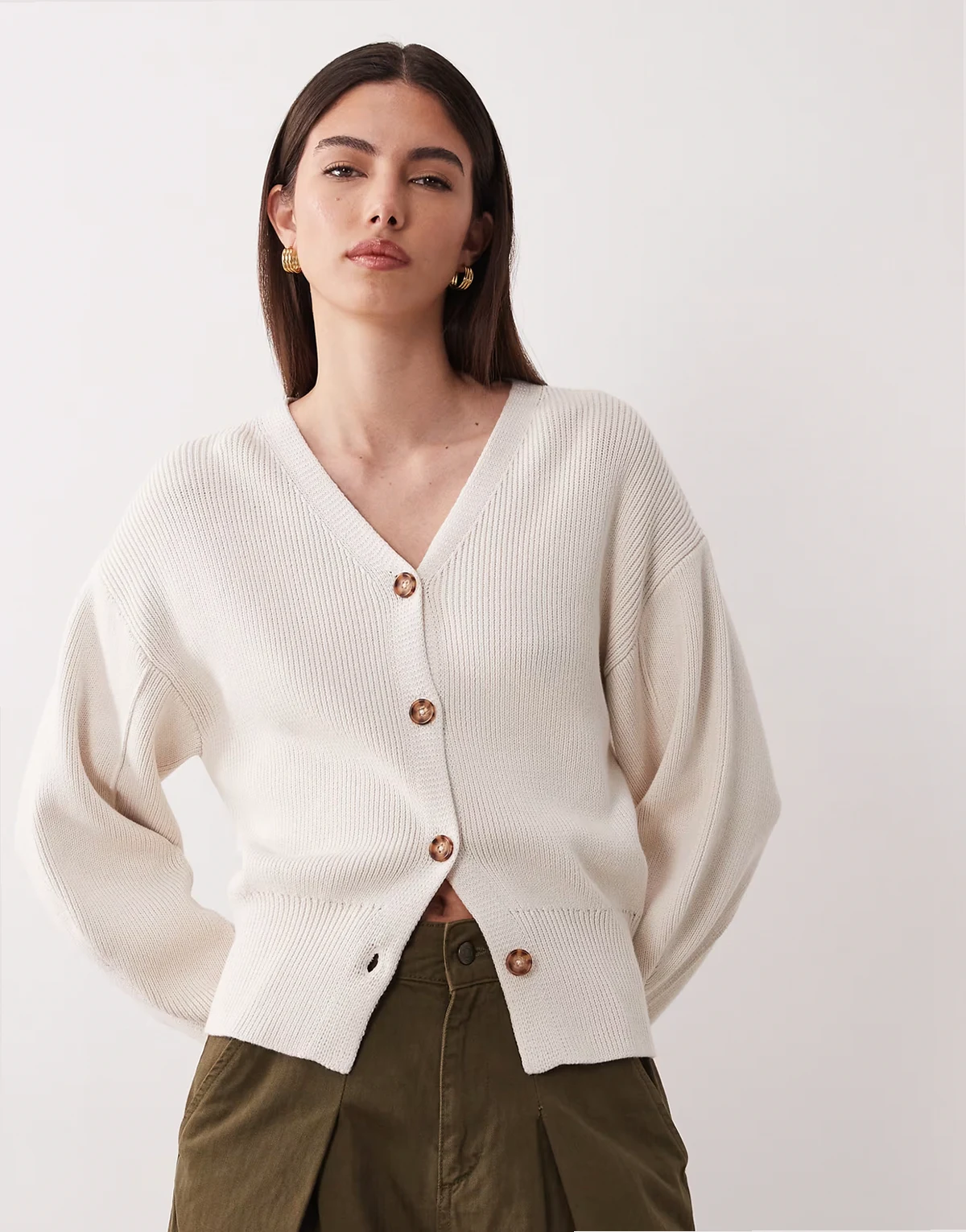 – Kremowy profilowany kardigan zwężany w talii