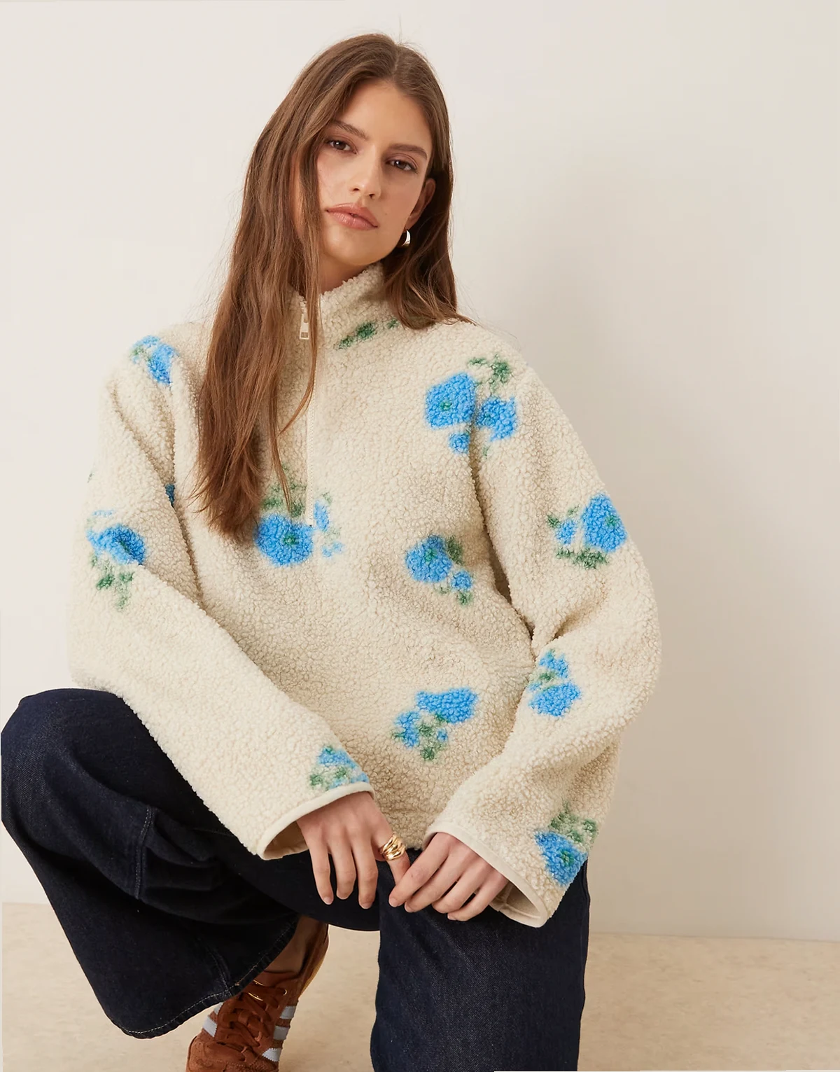 – Beżowa kurtka z kożuszka w kwiatowy wzór z zapięciem na zamek pod szyją