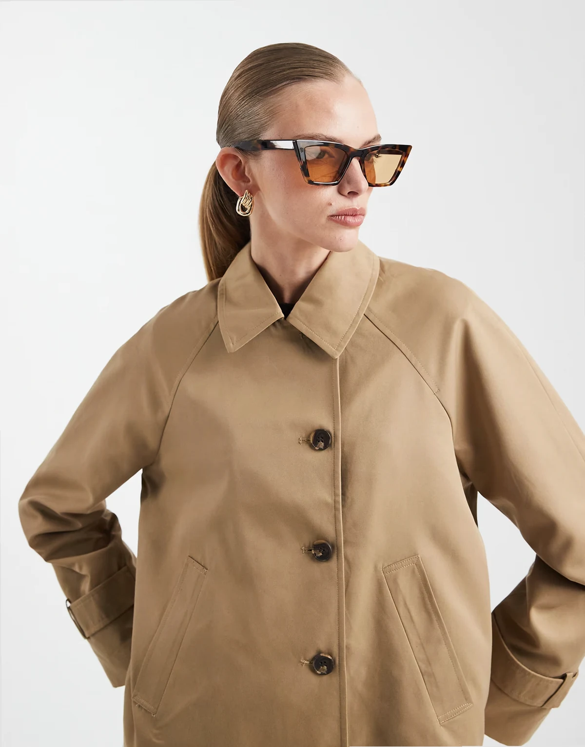 – Beżowa kurtka z asymetrycznym zapięciem na guziki