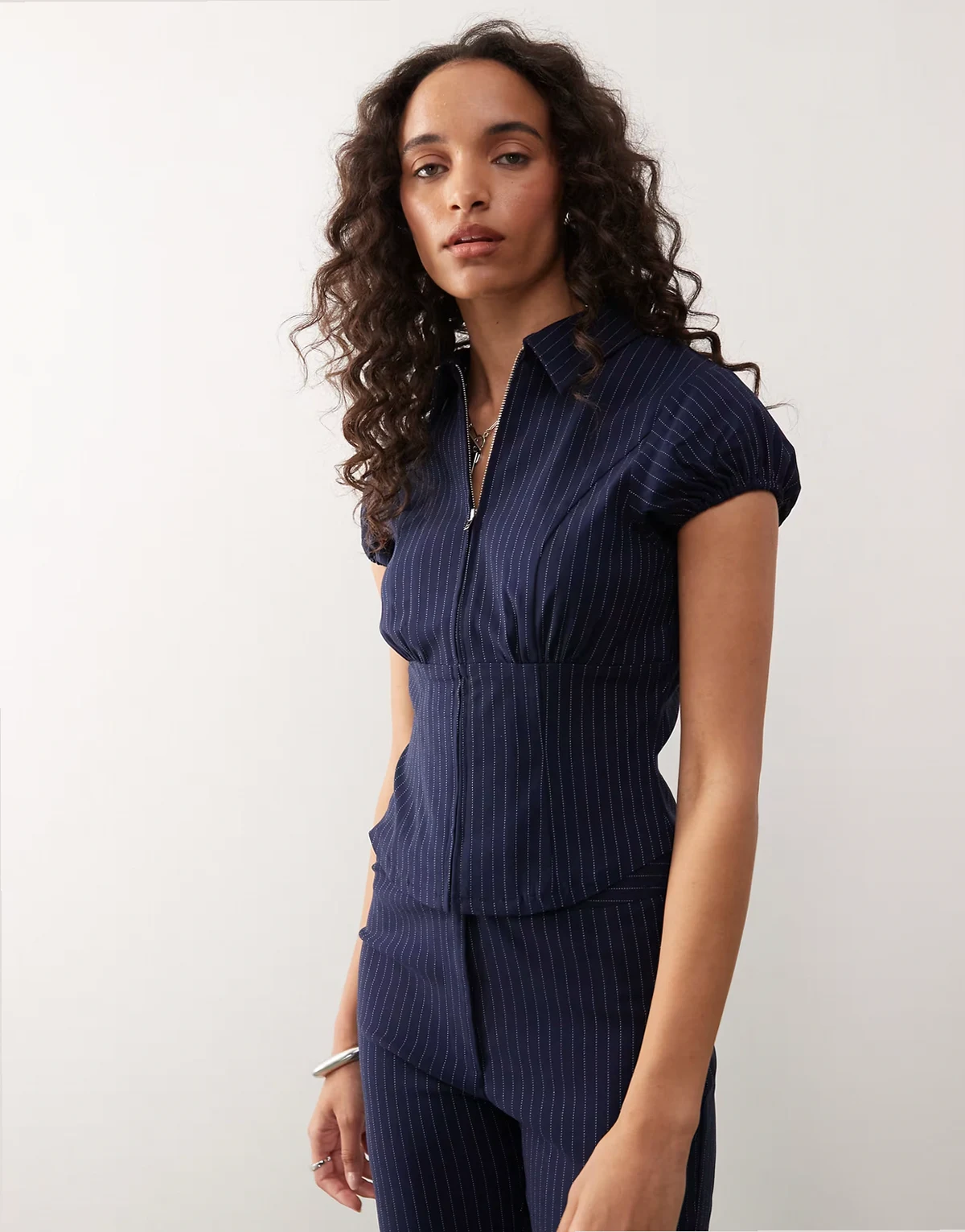 – Zapinana na suwak dopasowana granatowa koszula w prążki