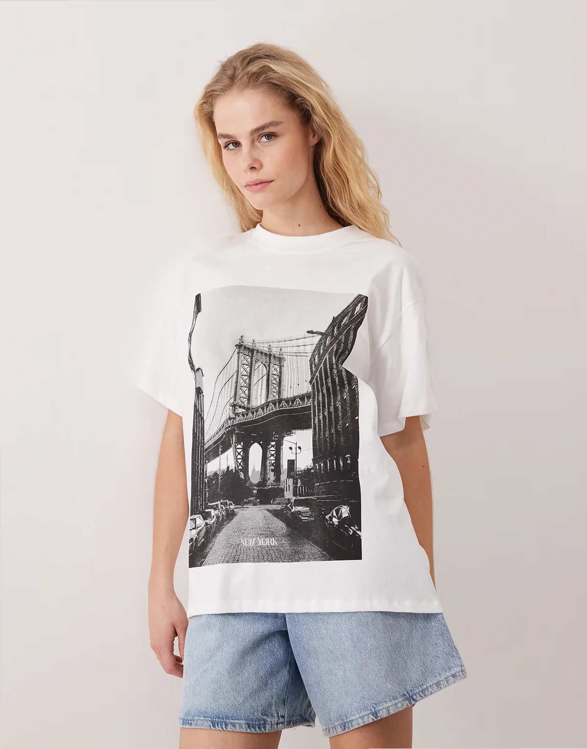 – Biały top oversize z krótkimi rękawami i nadrukiem „New York”