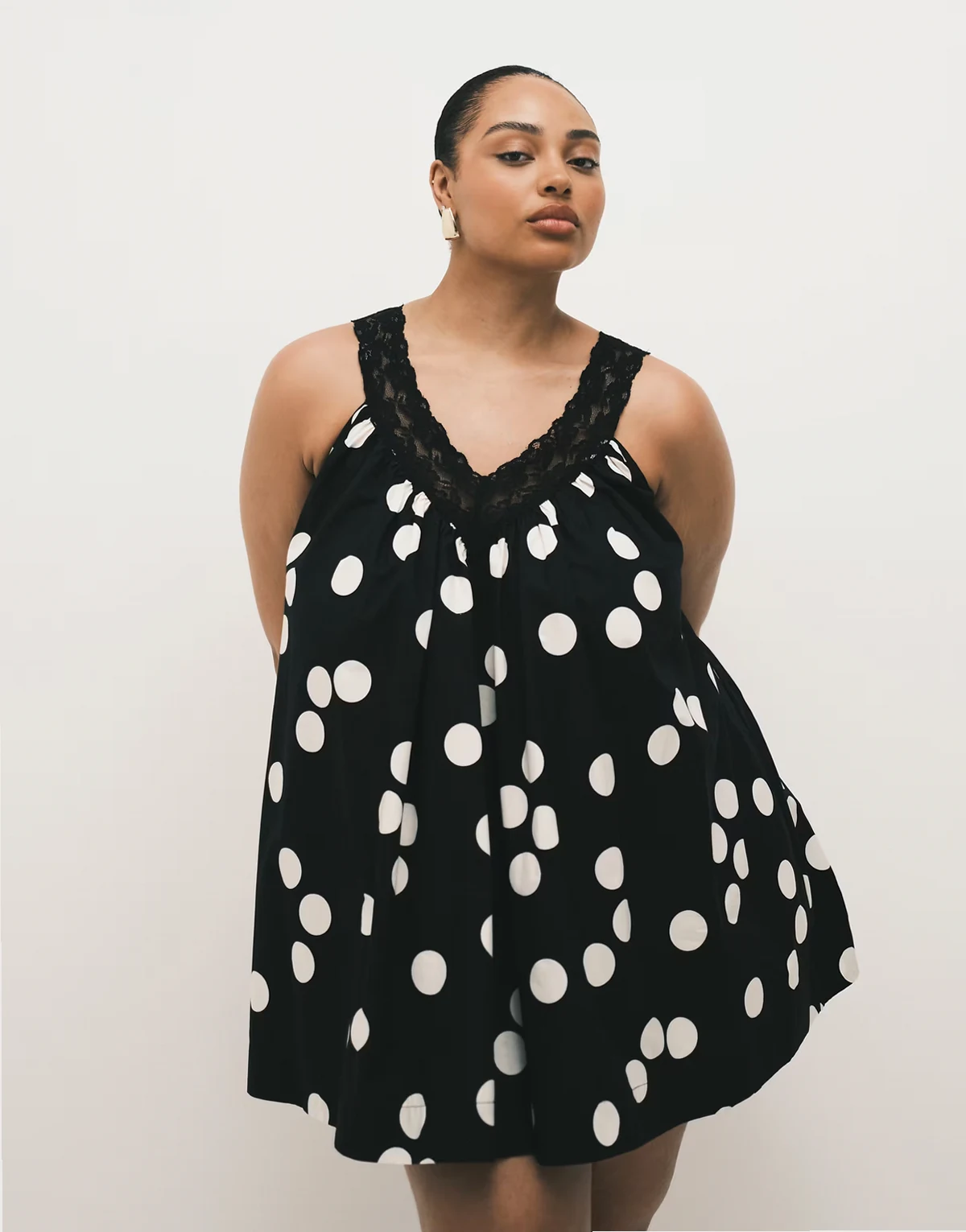 ASOS DESIGN Curve – Sommerliches Mini-Hängerkleid aus Popeline in Schwarz-Weiß gepunktet mit V-Ausschnitt und Spitzen-Overlay