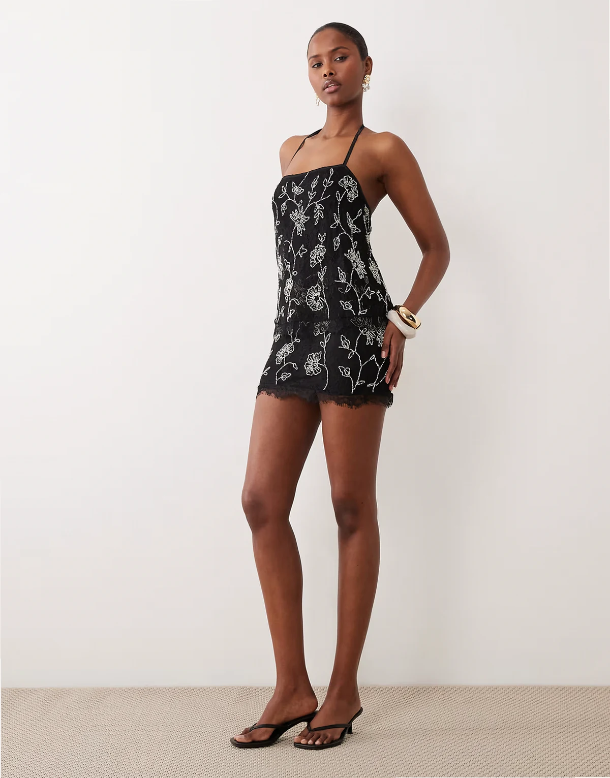 – Minikleid aus Spitze mit mehrlagigem Oberteil und figurbetontem Rock in Schwarz-Weiß mit durchgehender Verzierung