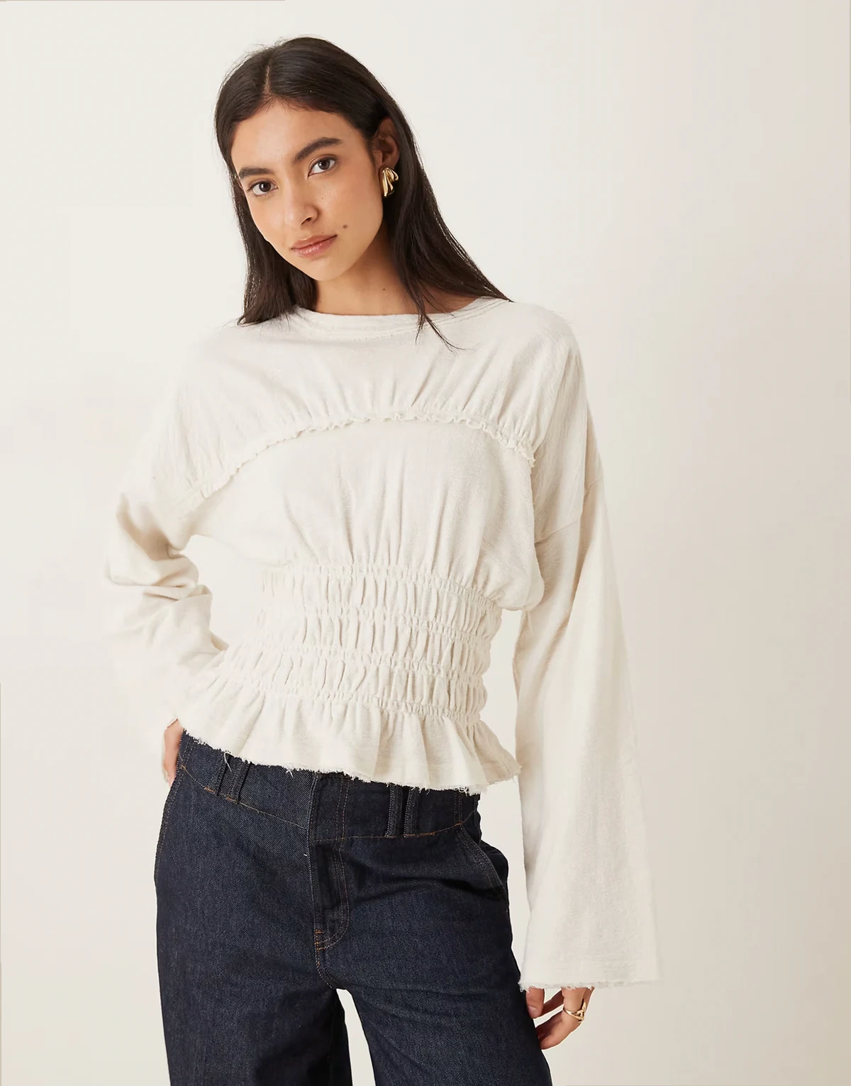 – Langärmliges T-Shirt in Creme mit Noppenstruktur und gesmokter Taille