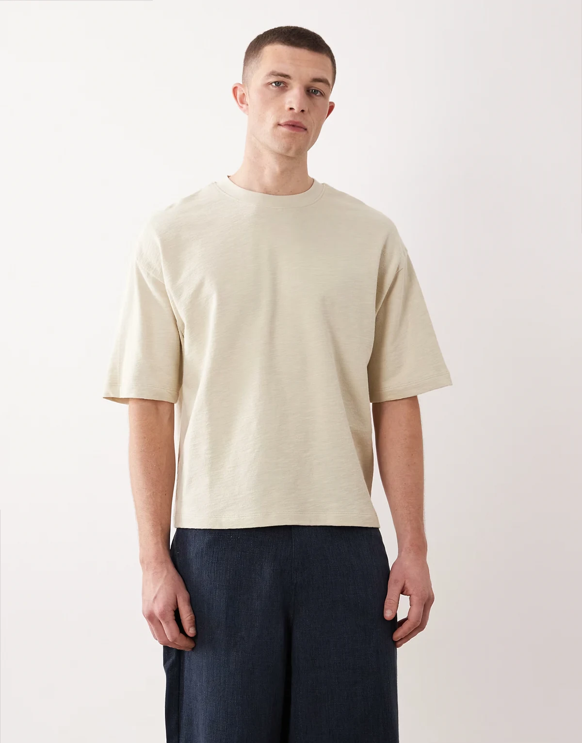 – Szarobeżowy fakturowany T-shirt oversize o pudełkowym kroju