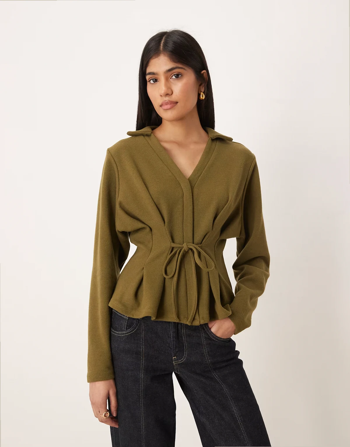 – Bardzo miękki ciemnooliwkowy top z długimi rękawami, kołnierzykiem polo i wcięciem i wiązaniem w talii