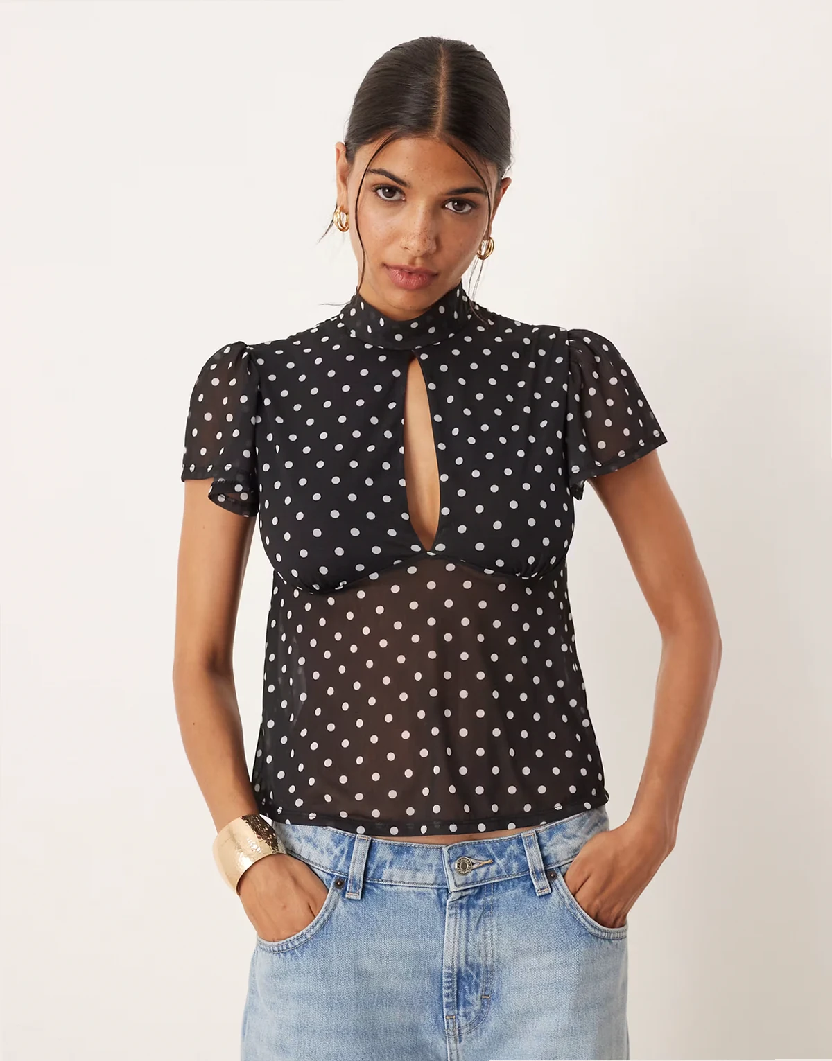 – Zwiewny czarny siateczkowy top z rozkloszowanymi rękawami, wiązaniem na plecach i wzorem w groszki